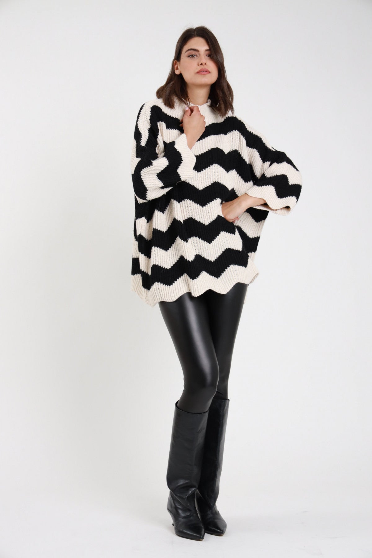 Leggings ecopelle neri donna - vista laterale con maglione chevron bianco e nero e stivali neri