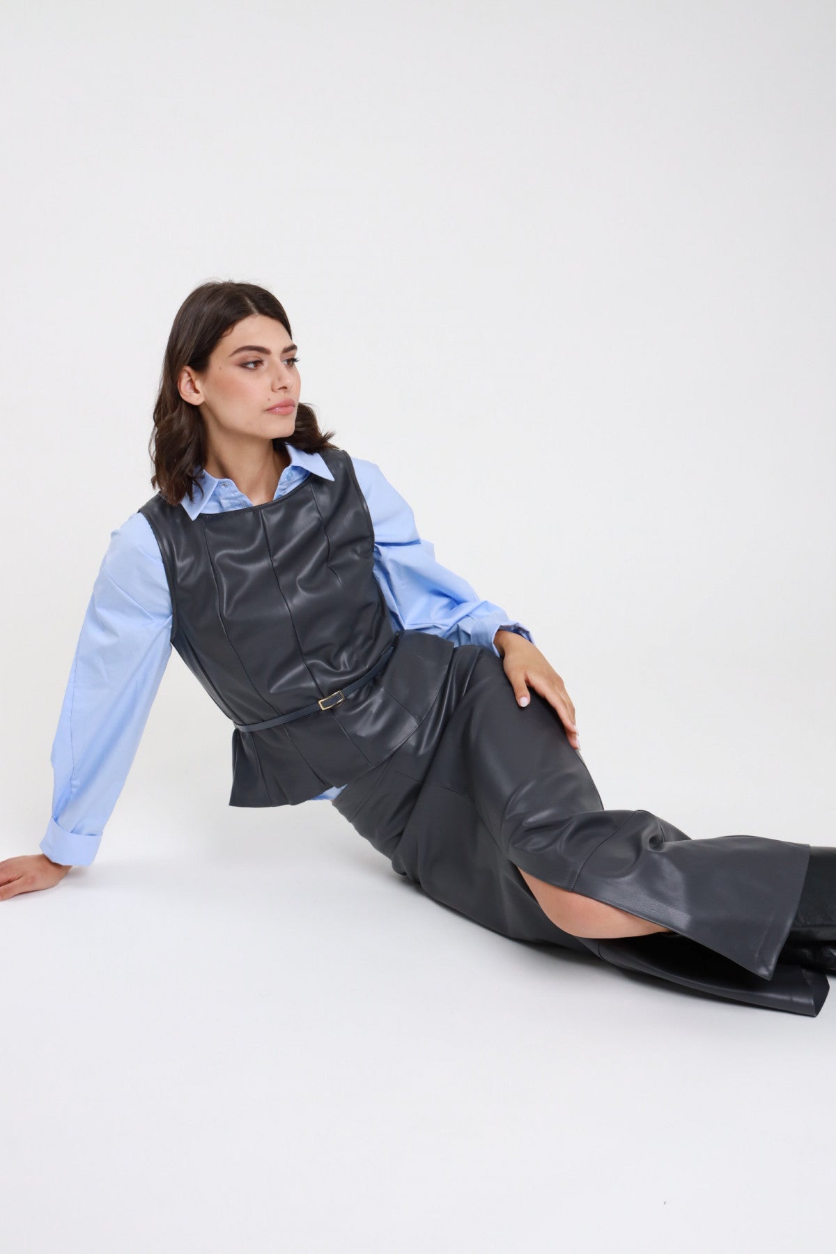 Gonna longuette ecopelle grigio antracite donna Susy Mix – spacco frontale vista seduta a terra con top ecopelle e camicia azzurra
