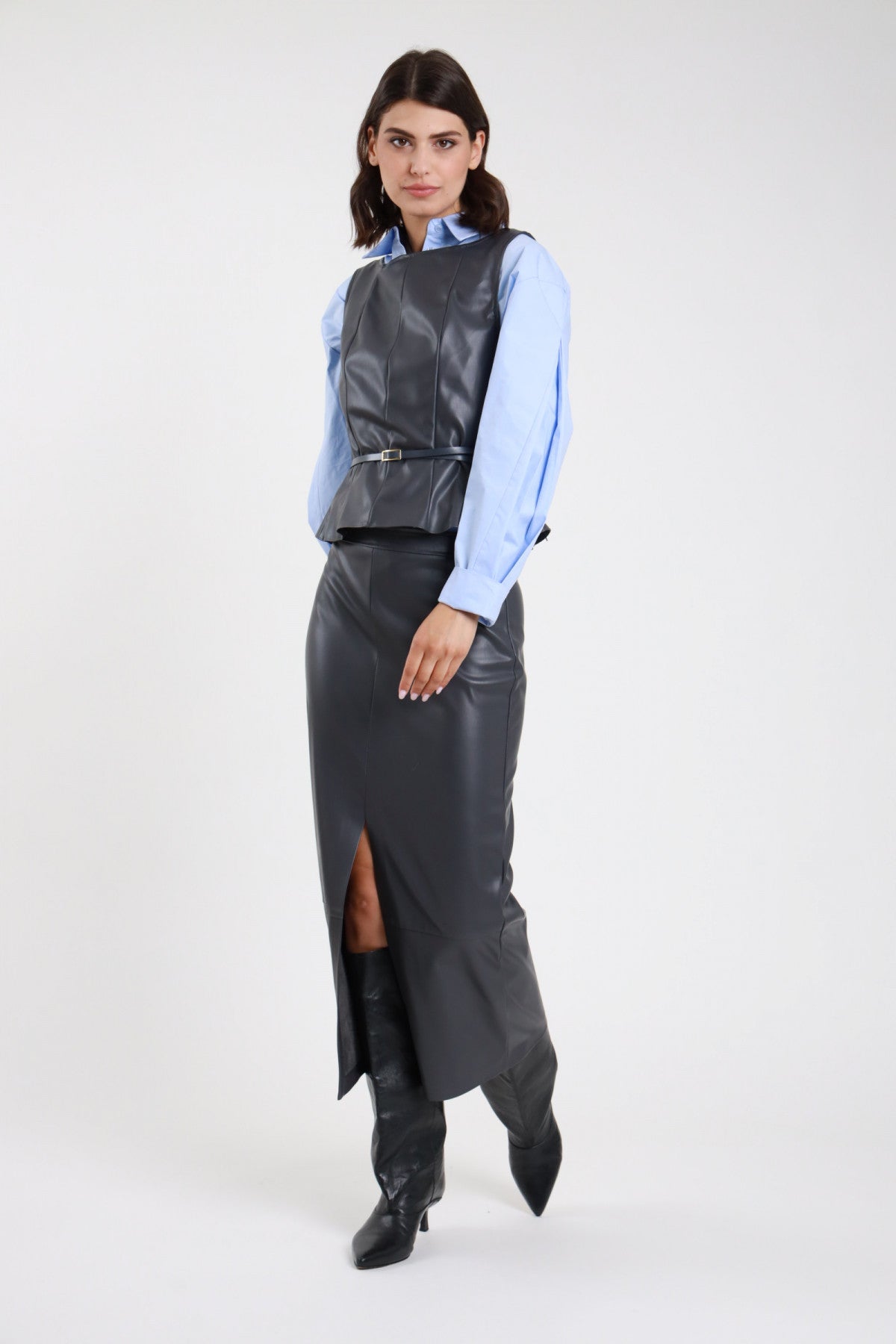 Gonna longuette ecopelle grigio antracite donna Susy Mix – silhouette aderente vista laterale con top ecopelle e camicia azzurra e stivali neri