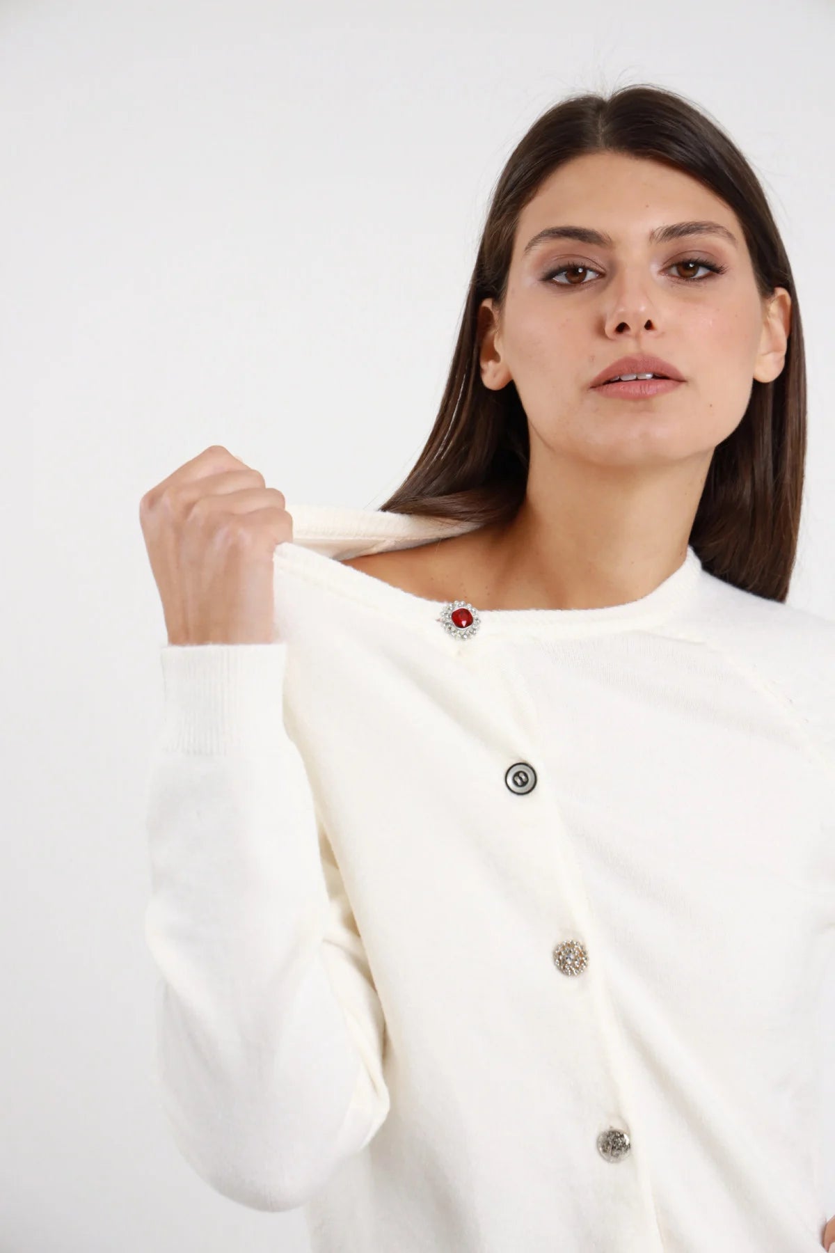 Cardigan Crop Bottoni Gioiello bianco panna 49% viscosa dettaglio ravvicinato spalla girocollo primo bottone strass rotondo rosso cornice argento - modella busto dettaglio spalla collo mano capelli castani scuri bob sfondo bianco