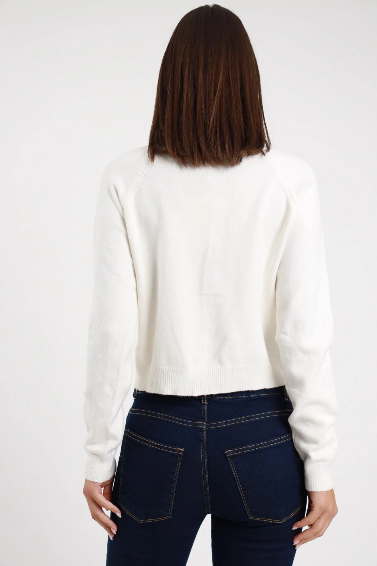 Cardigan Crop Bottoni Gioiello bianco panna 49% viscosa girocollo ampio bottoni gioiello misti bruniti argentati dorati manica lunga bordo costina fitted crop frontale braccia alzate - modella busto frontale braccia alzate sguardo frontale intenso capelli castani scuri bob sfondo bianco jeans navy scuro