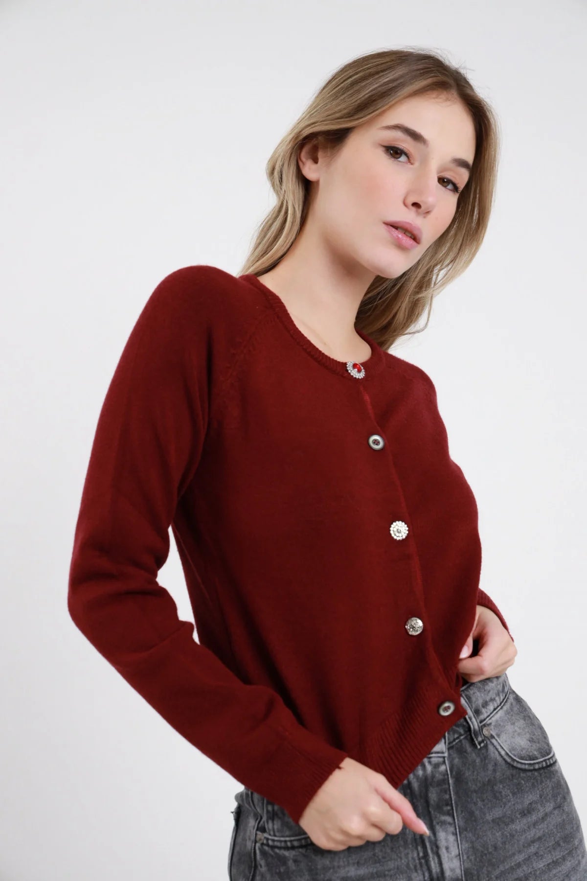 Cardigan Crop Bottoni Gioiello nero 49% viscosa girocollo ampio bottoni gioiello misti strass rosso bruniti argentati manica lunga bordo costina fitted crop aperto - modella busto 3/4 frontale mano fianco aperto sguardo frontale capelli biondi ondulati sfondo bianco jeans marrone cioccolato