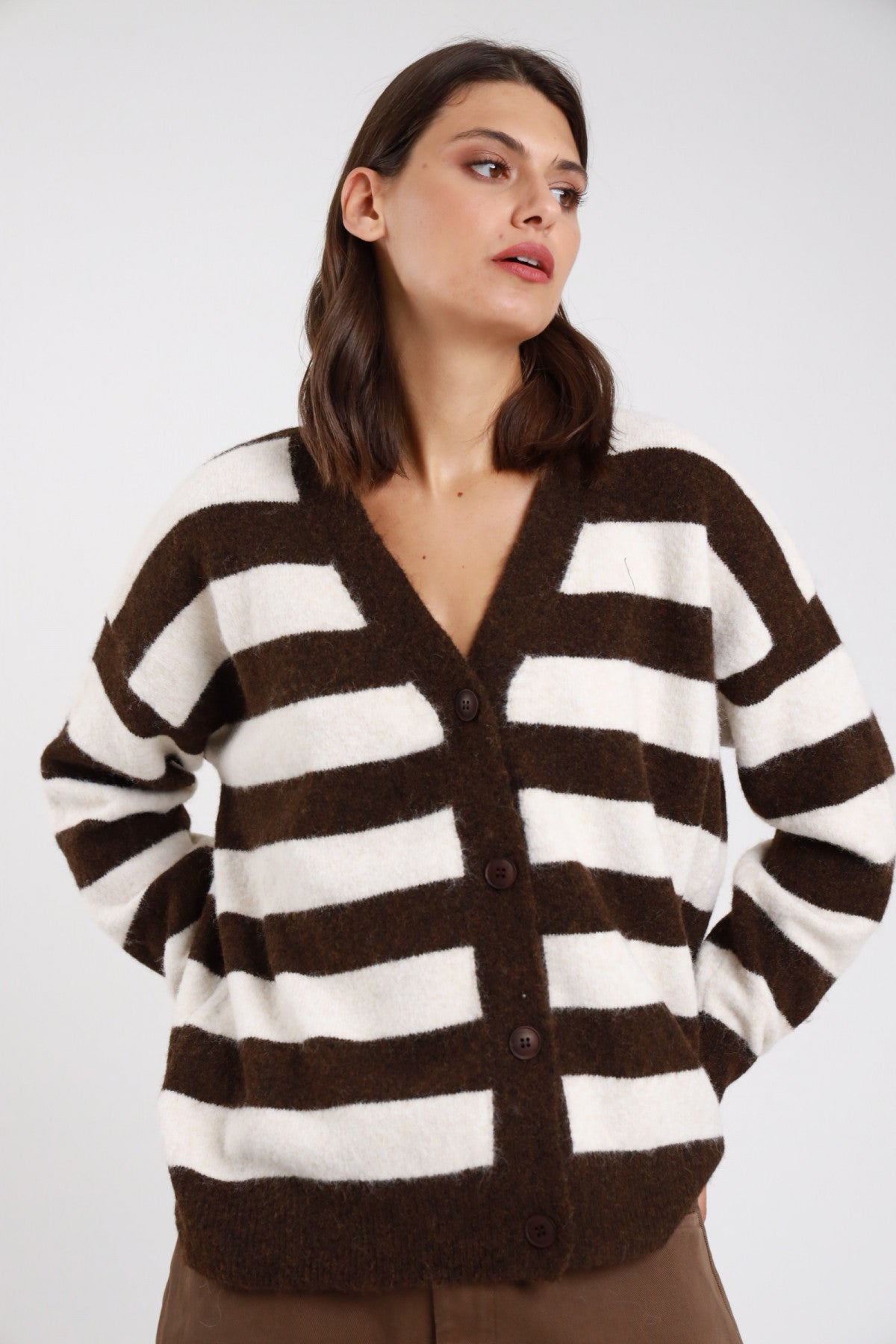 Cardigan righe maxi cioccolato moro panna avorio eyelash fluffy frontale busto mani fianchi scollo V profondo abbottonatura 4 bottoni resina manica dropped shoulder balloon polsino coste corpo oversize relaxed - modella frontale busto mani fianchi sguardo laterale alto pantaloni tabacco capelli neri mossi