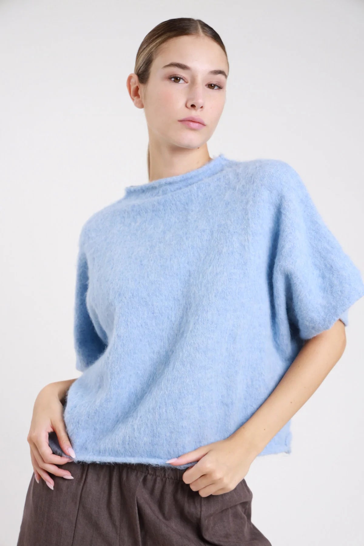 Pullover maniche corte bordeaux borgogna mohair batwing oversize soffice - modella busto tre quarti braccio alzato sguardo laterale gonna grigio scuro capelli castani raccolti