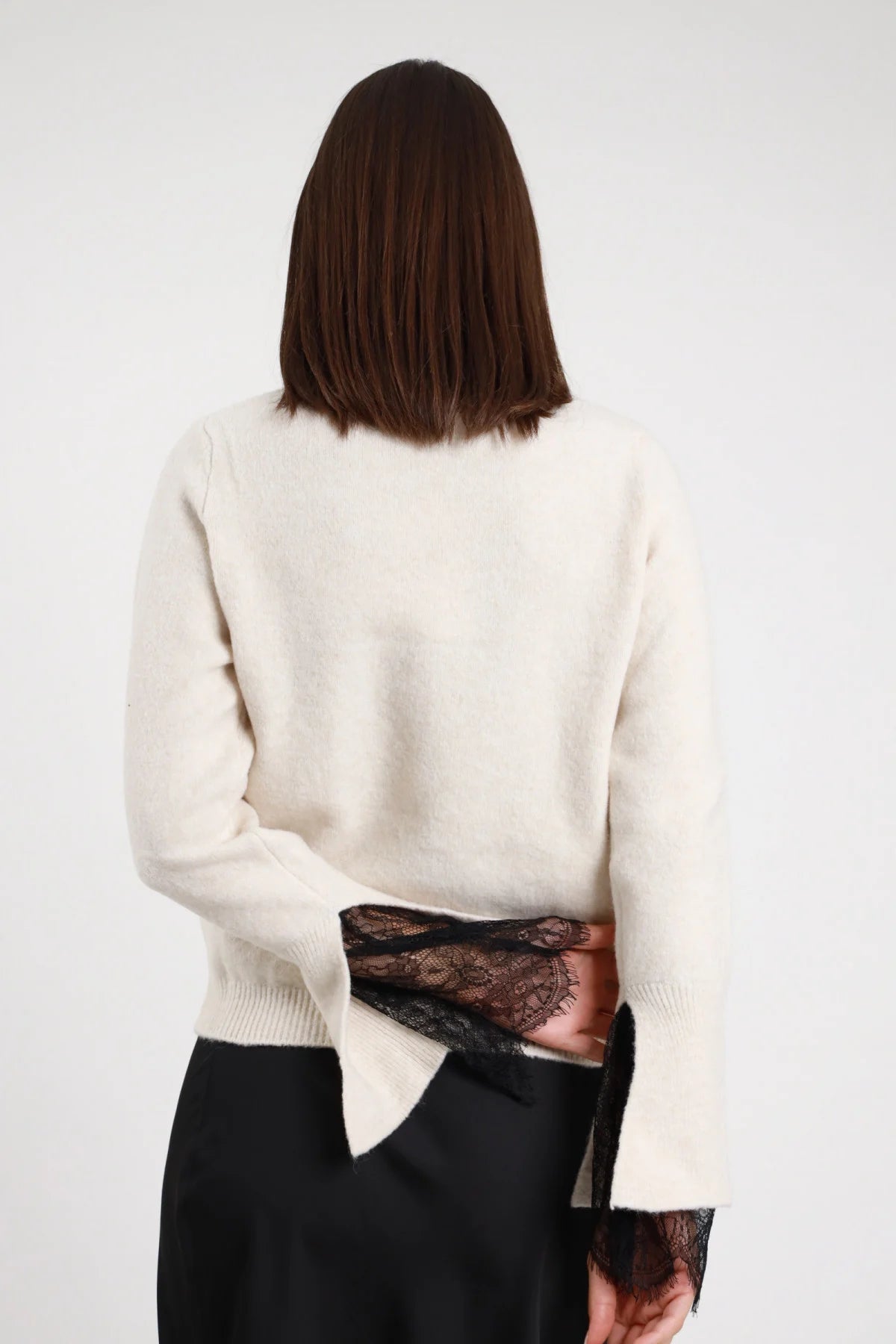 Pullover Manica Pizzo panna avorio crema 46% poliestere 8% lana girocollo manica lunga polsino costina volant pizzo nero floreale paisley molto visibile retro liscio posteriore intera - modella intera posteriore capelli castani scuri lisci sfondo bianco gonna satin nera abbinata