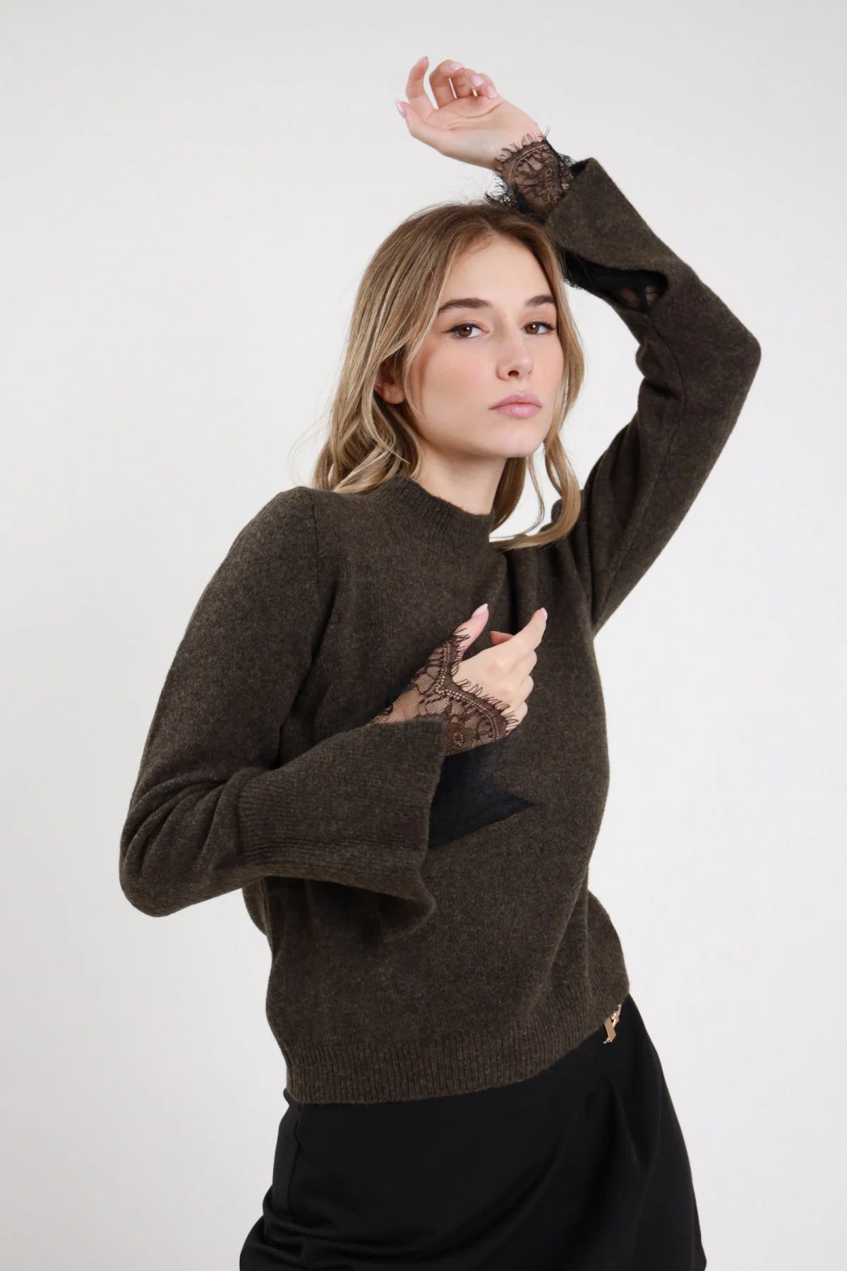 Pullover Manica Pizzo verde militare oliva melange 46% poliestere 8% lana girocollo tondo manica lunga ampia polsino costina volant pizzo nero floreale paisley vaporoso lungo zip laterale dorata silhouette relaxed frontale busto 3/4 - modella busto 3/4 mano petto sguardo frontale capelli biondi ondulati sfondo bianco gonna satin nera abbinata