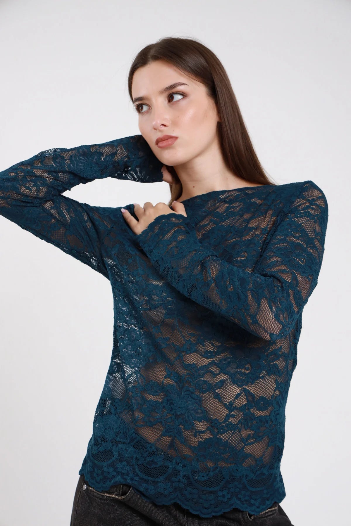 Maglia pizzo stretch floreale rose petrolio teal verde acqua scuro semitrasparente barchetta boat neck off-shoulder manica lunga aderente polsino smerlato fitted frontale tre quarti mano collo - modella frontale tre quarti mano collo sguardo laterale capelli castani lisci lunghi sfondo bianco jeans nero