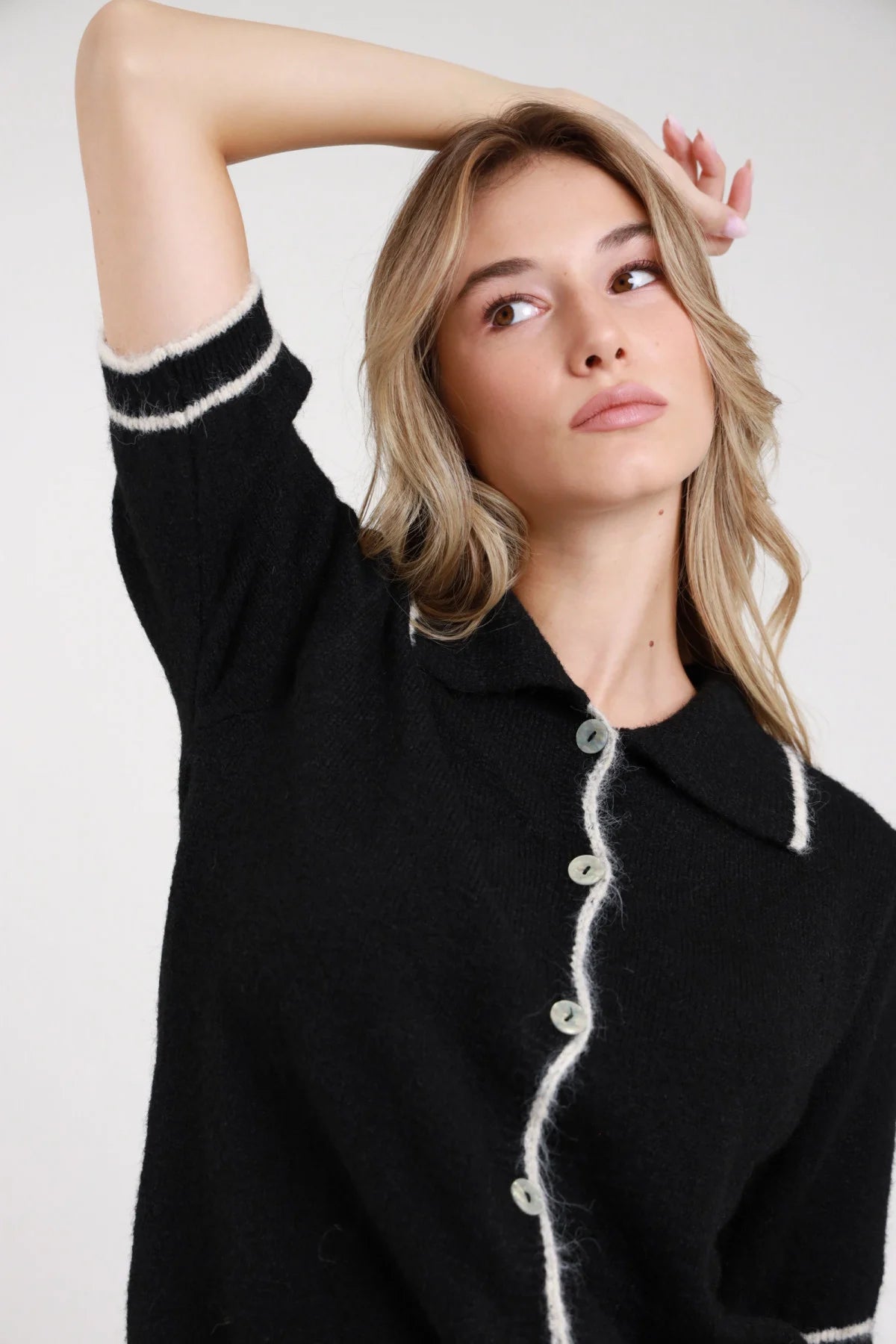 Polo maglia boucle nero bordino eyelash bianco panna retro intera manica corta dropped shoulder orlo inferiore bordino wavy corpo relaxed crop - modella retro intera mano vita sguardo basso pantaloni animalier leopard capelli biondi mossi lunghi