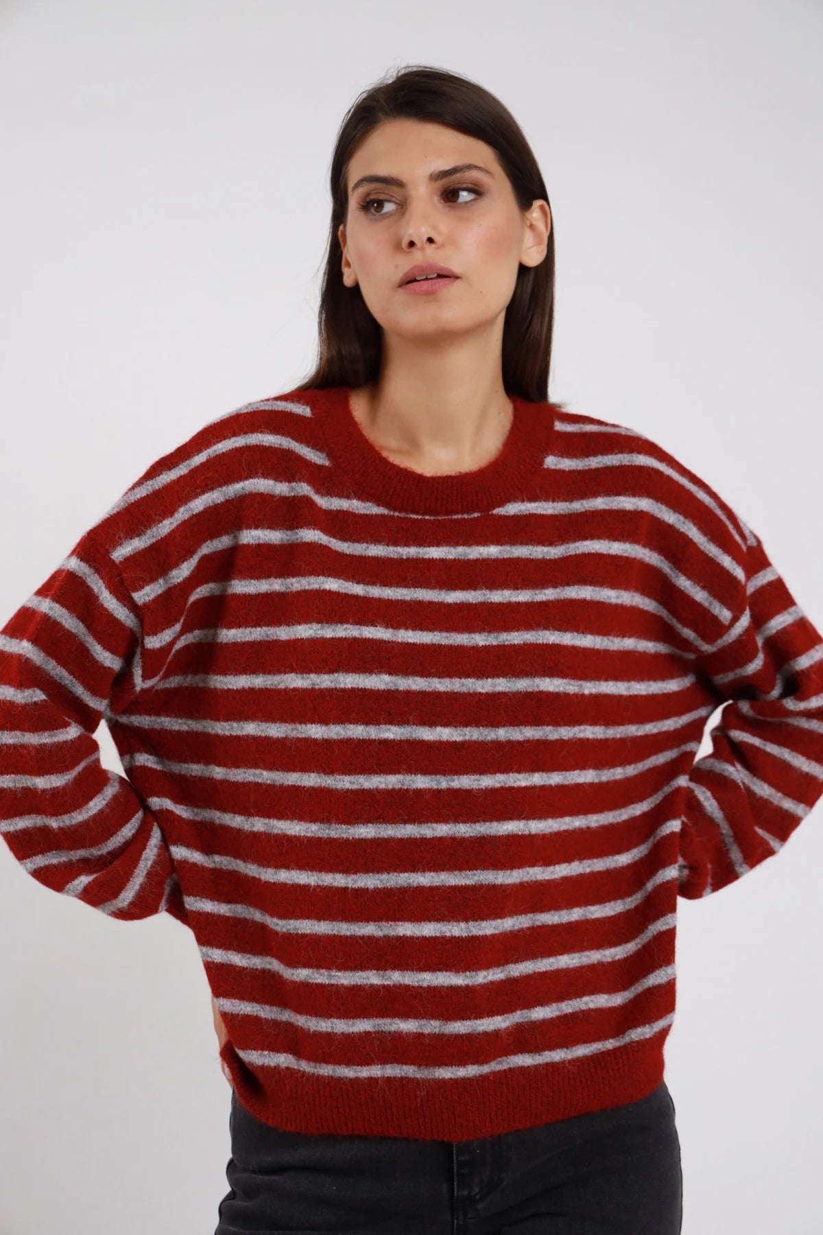 Pullover Girocollo Oversize Righe Orizzontali bordeaux ruggine grigio lurex argentato shimmer misto lana effetto alpaca manica raglan ampia polsino costina silhouette boxy - modella busto frontale posa mani fianchi dietro sguardo laterale alto capelli castani lisci sfondo bianco jeans grigio scuro