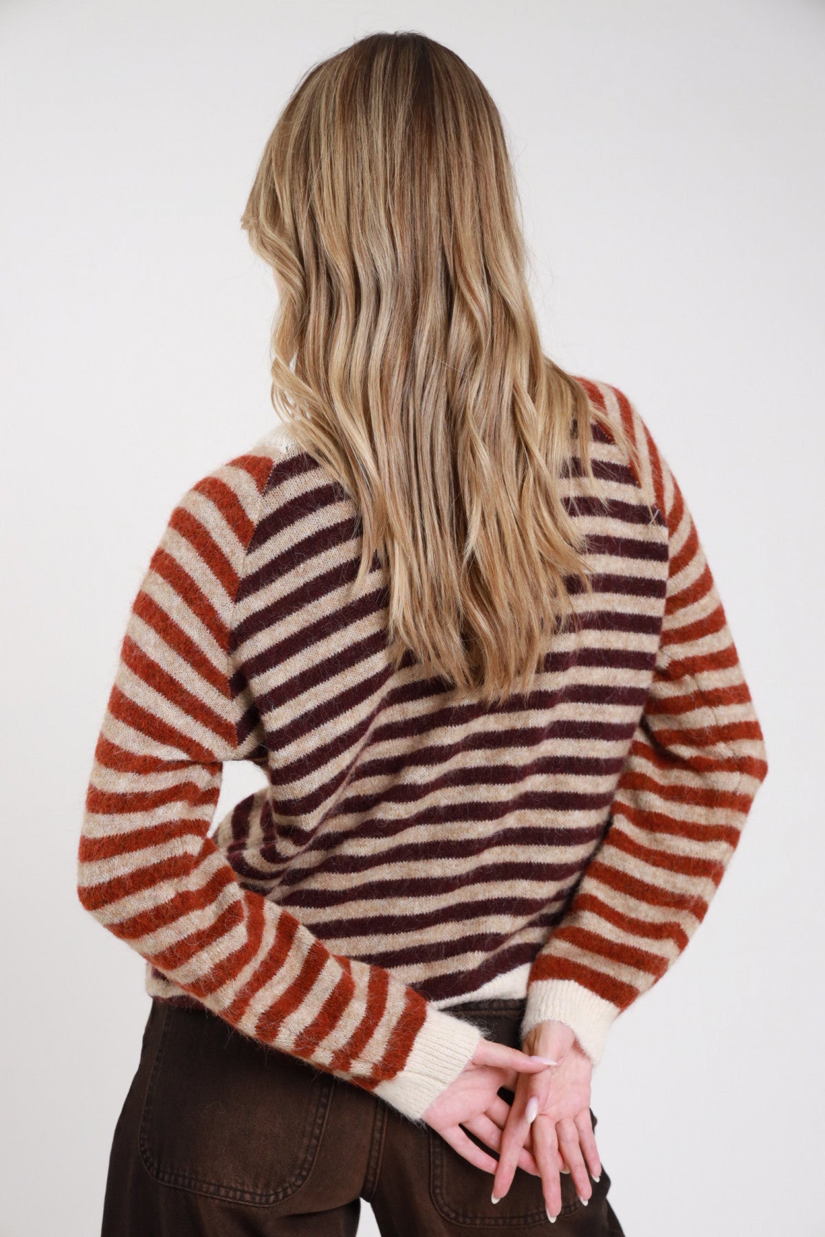 Pullover righe contrasto borgogna ruggine panna frontale intera girocollo costina panna raglan oblique - modella frontale intera mani fianchi sguardo frontale jeans marrone scuro capelli biondi ondulati