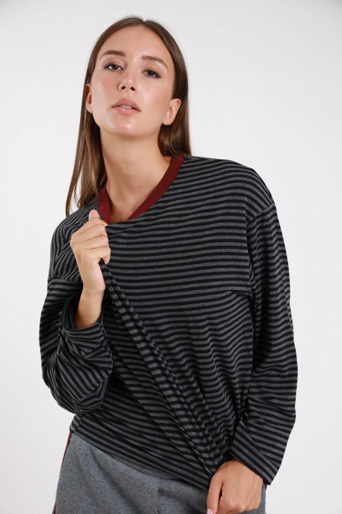 Maglia righe bicolor antracite grigio retro intera manica lunga dropped shoulder corpo boxy orlo dritto costina borgogna - modella retro intera mani intrecciate dietro sguardo basso laterale gonna grigia capelli castani lisci