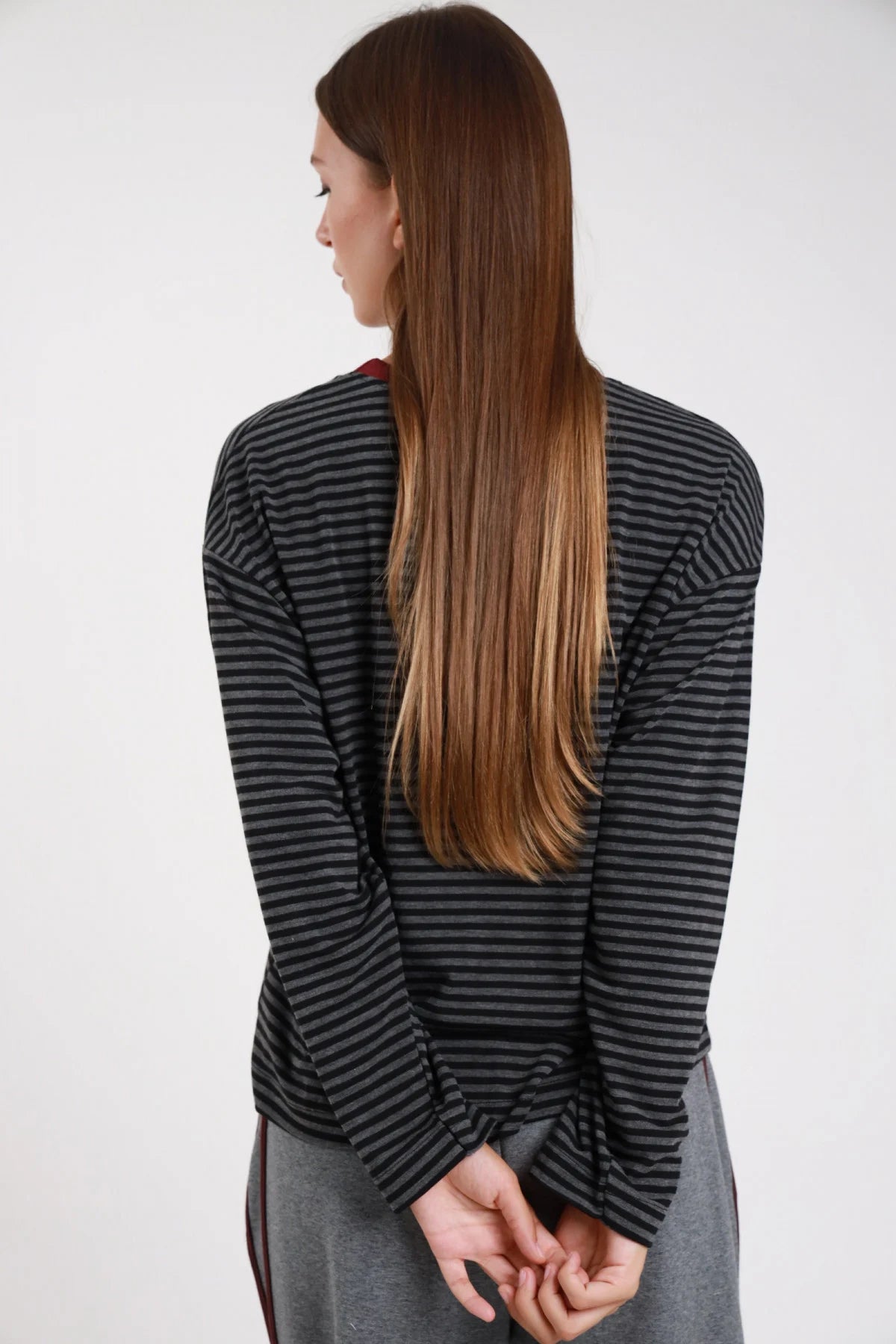 Maglia righe bicolor antracite grigio frontale busto mano colletto girocollo costina borgogna manica lunga dropped shoulder boxy - modella frontale busto mano colletto sguardo frontale gonna grigia capelli castani lisci