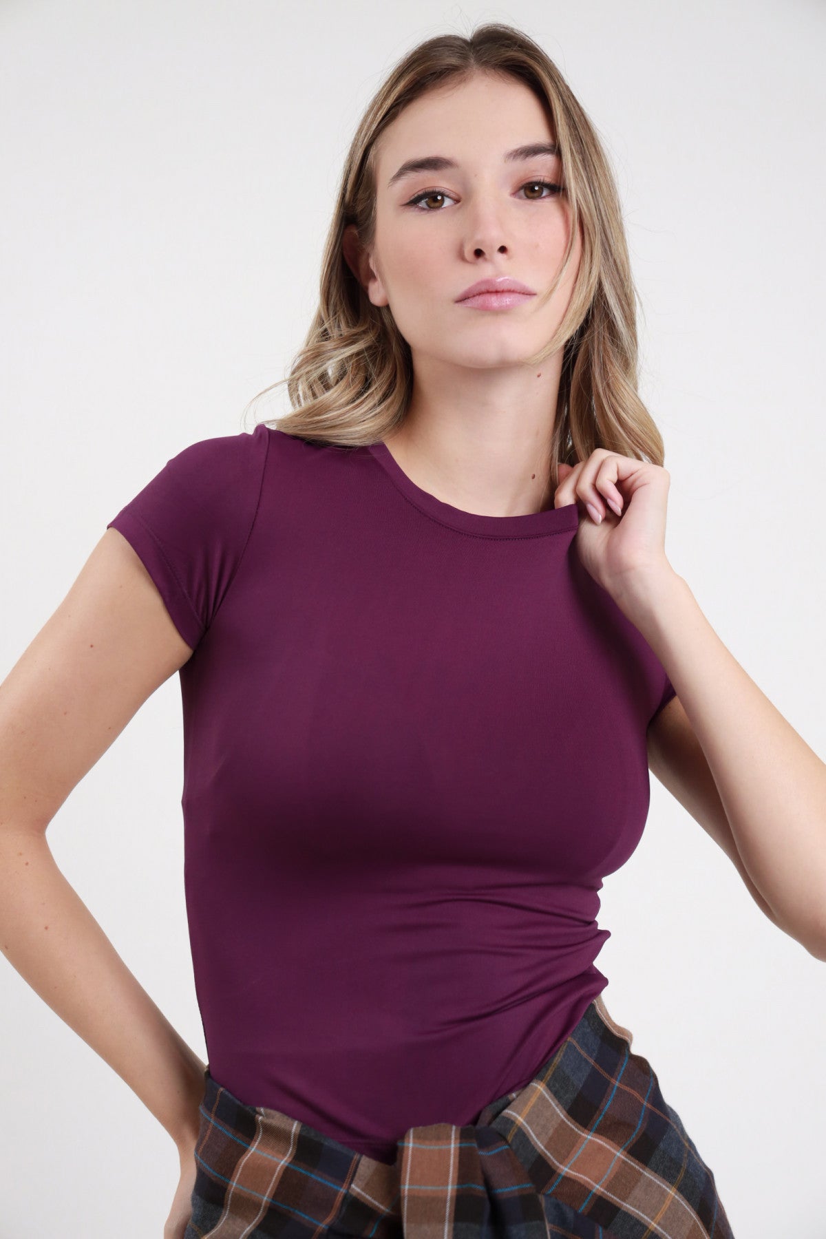 T-shirt Second Skin SMX Limited Edition viola melanzana 95% tactel fitted crop maniche corte cap sleeve silhouette aderente valorizzante busto frontale mano spalla sguardo frontale - modella busto frontale mano spalla sguardo frontale capelli biondi mossi sfondo bianco gonna tartan scozzese multicolor abbinata