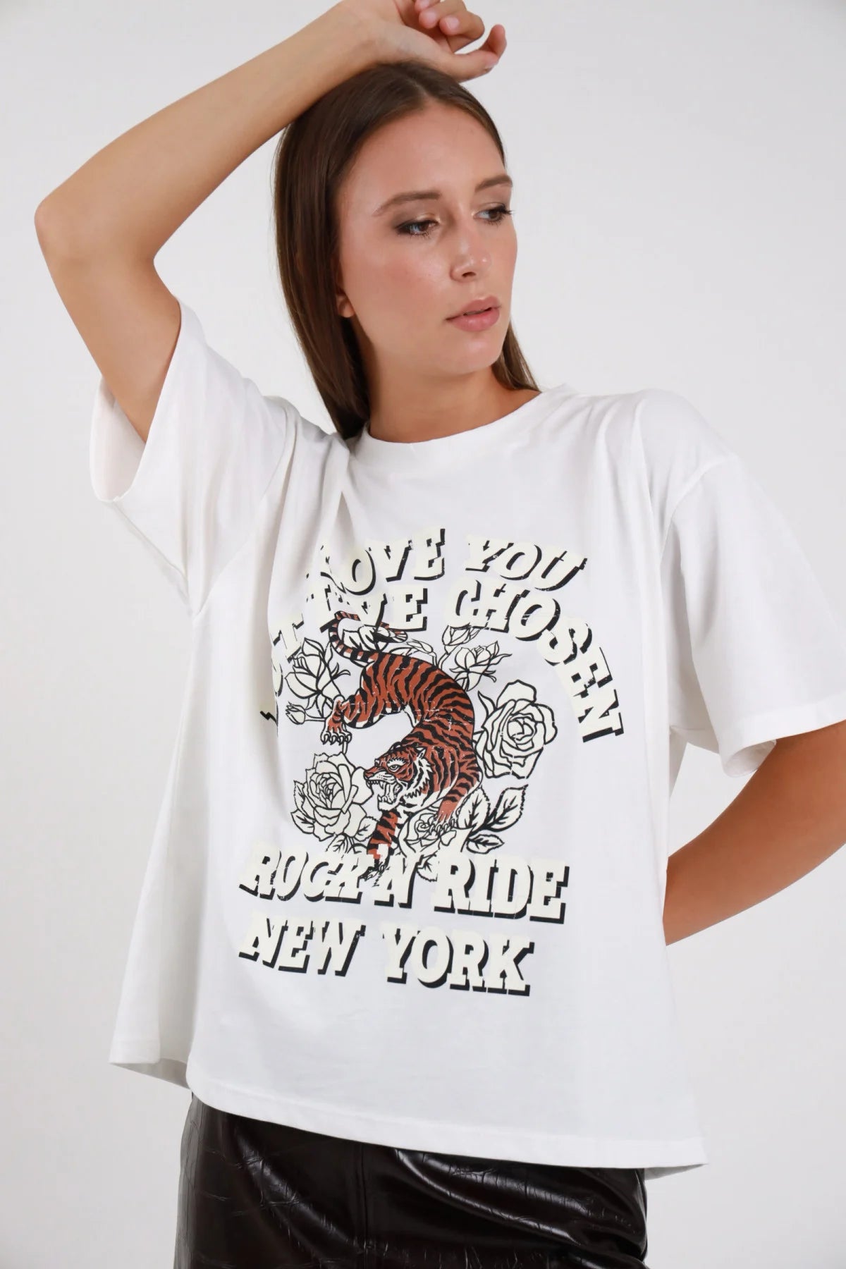 T-shirt Stampa rock tiger bianco oversize drop shoulder crop boxy stampa colorata tigre rose tattoo Rock'N Ride New York busto frontale 3/4 mano capelli mano fianchi - modella busto frontale 3/4 mano capelli sguardo laterale capelli castani lisci sfondo bianco gonna ecopelle nera