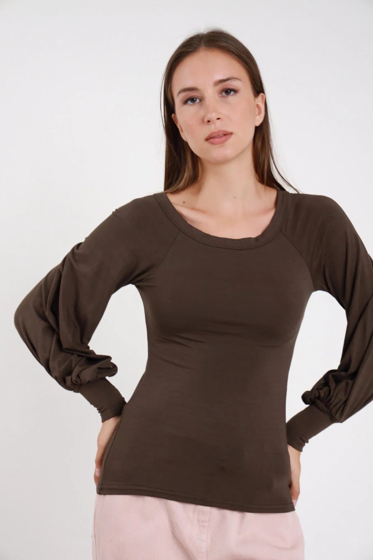 Maglia maniche ampie marrone scuro donna girocollo palloncino polsino elasticizzato - vista frontale mani sui fianchi con pantaloni rosa cipria