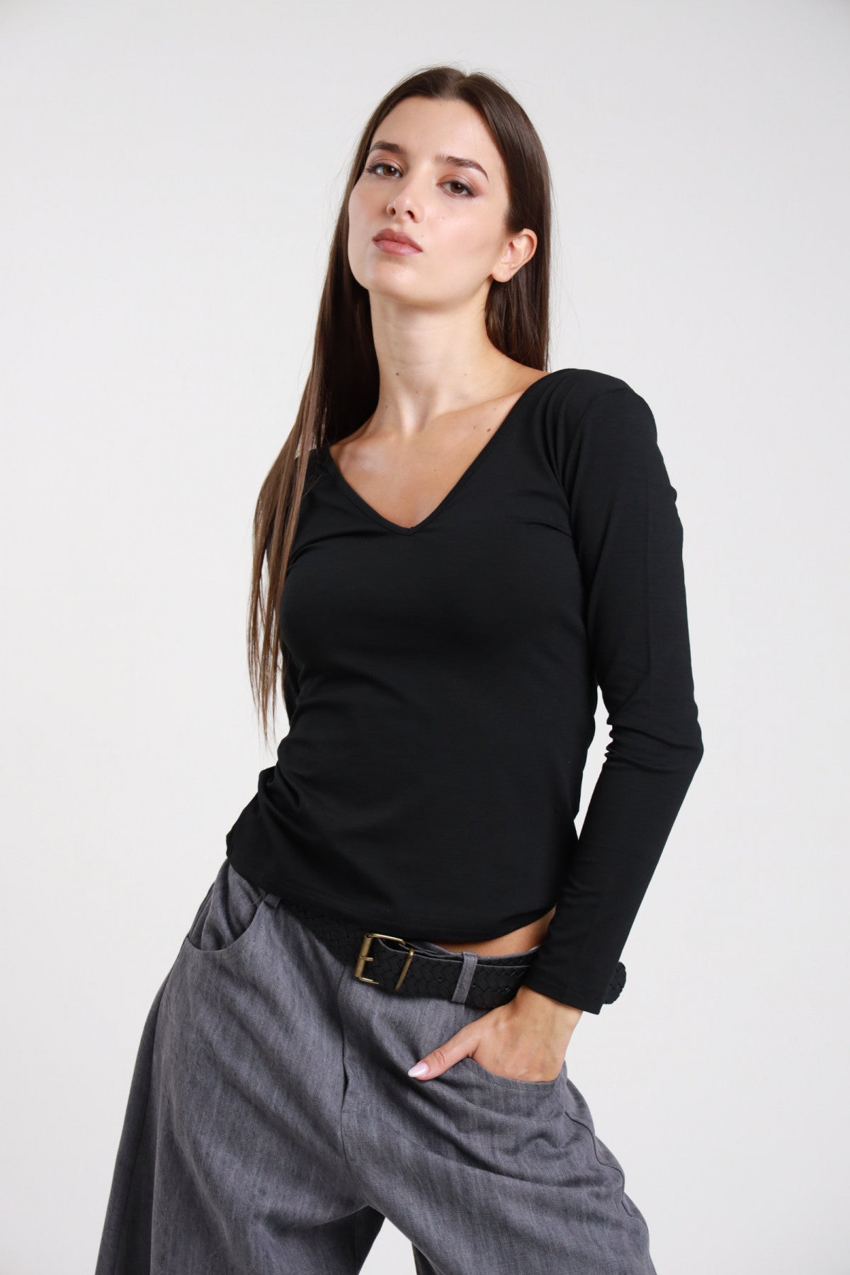 Maglia scollo V nera donna maniche lunghe aderente - vista frontale con pantaloni grigio antracite e cintura