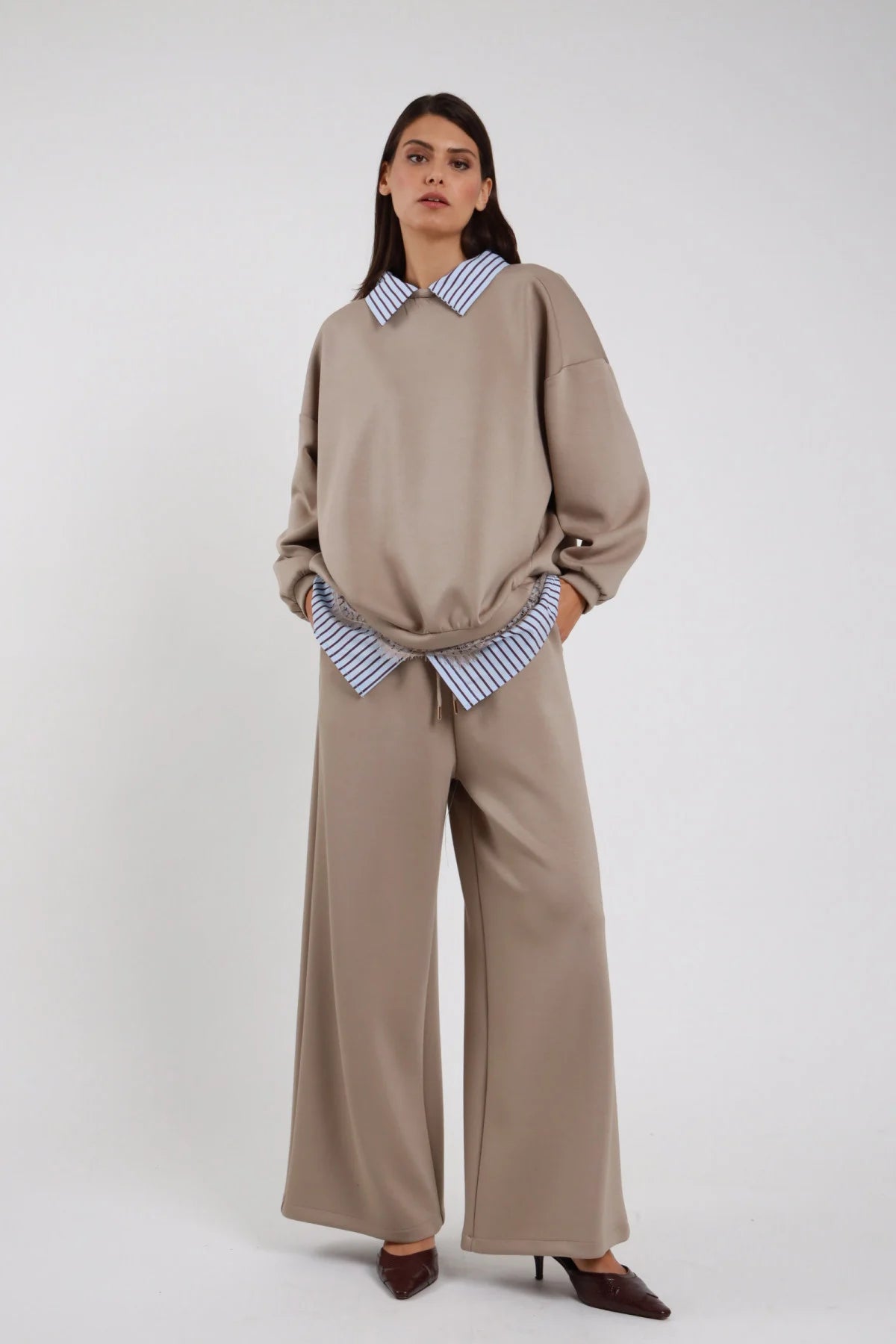 Pantaloni Wide Leg Coulisse Camicia Righe tortora beige caldo 48% rayon coulisse cordino vita striscia camicia righe blu bianco fuoriesce elastico vita gamba wide leg larghissima caduta fluida frontale intera - modella intera frontale mani tasche sguardo frontale intenso capelli castani lisci sfondo bianco felpa camicia pizzo tortora coordinata scarpe tacco marrone