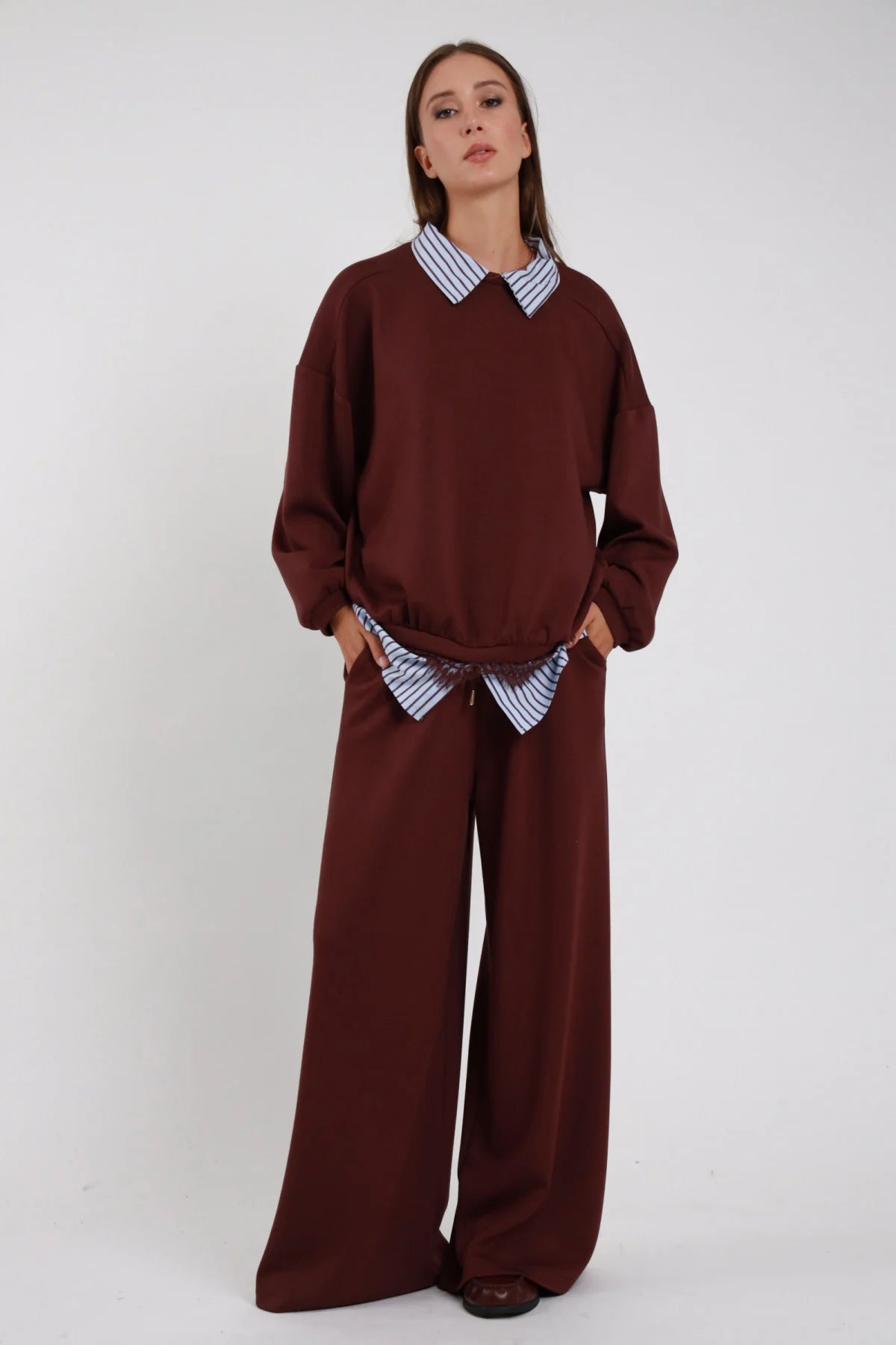 Pantaloni Wide Leg Coulisse Camicia Righe bordeaux prugna 48% rayon coulisse cordino vita striscia camicia righe blu bianco fuoriesce gamba wide leg larghissima caduta fluida frontale intera - modella intera frontale mani tasche sguardo frontale intenso capelli castani lisci sfondo bianco felpa bordeaux coordinata