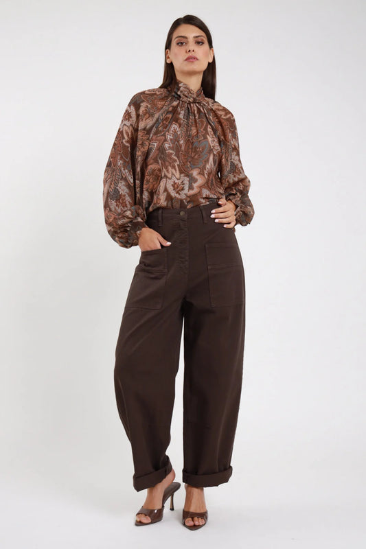 Jeans Tinto Capo Tasconi marrone cioccolato scuro wide barrel tasconi applicati vita alta risvolto frontale intera mano tasca - modella frontale intera mano tasca sguardo frontale capelli castani lisci sfondo bianco blusa paisley marrone sandali marroni tacco