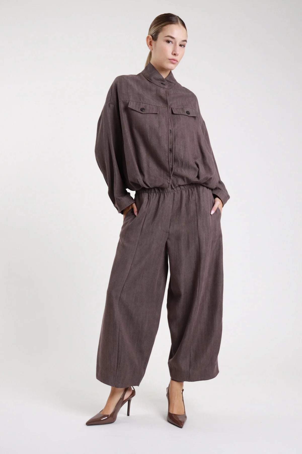 Pantalone gamba larga balloon lino fango taupe scuro coulisse - modella frontale intera con bomber abbinato fango décolleté marroni capelli castani lisci sguardo frontale