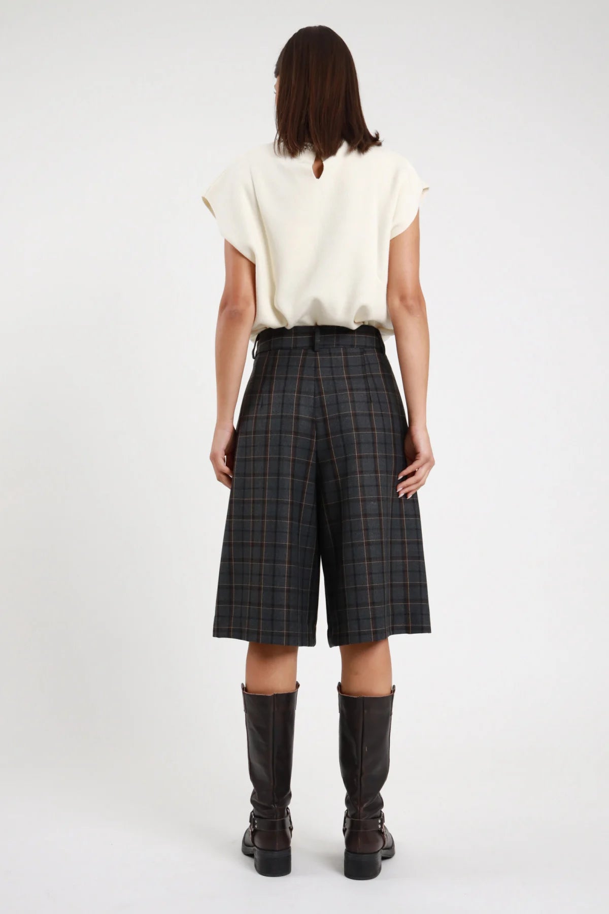 Bermuda Check windowpane nero antracite 63% poliestere viscosa pieghe volumetriche ampie tasche posteriori pattina gamba wide leg culotte posteriore intera - modella intera posteriore capelli castani lisci sfondo bianco top panna stivali ginocchio neri pelle