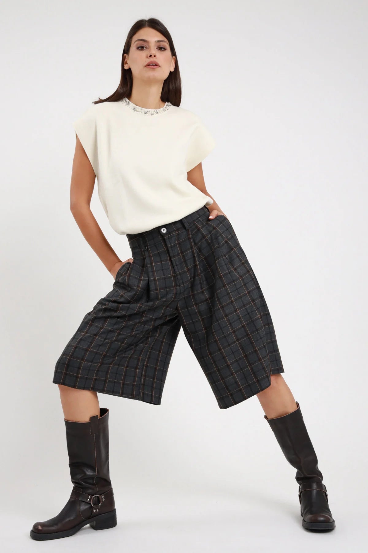 Bermuda Check windowpane nero antracite filino dorato 63% poliestere viscosa vita alta bottone passanti pieghe sartoriali ampie tasche laterali filo silhouette wide leg culotte frontale 3/4 laterale posa gambe larghe - modella 3/4 laterale posa gambe larghe sguardo 3/4 alto capelli castani lisci sfondo bianco top panna senza maniche strass stivali ginocchio neri pelle