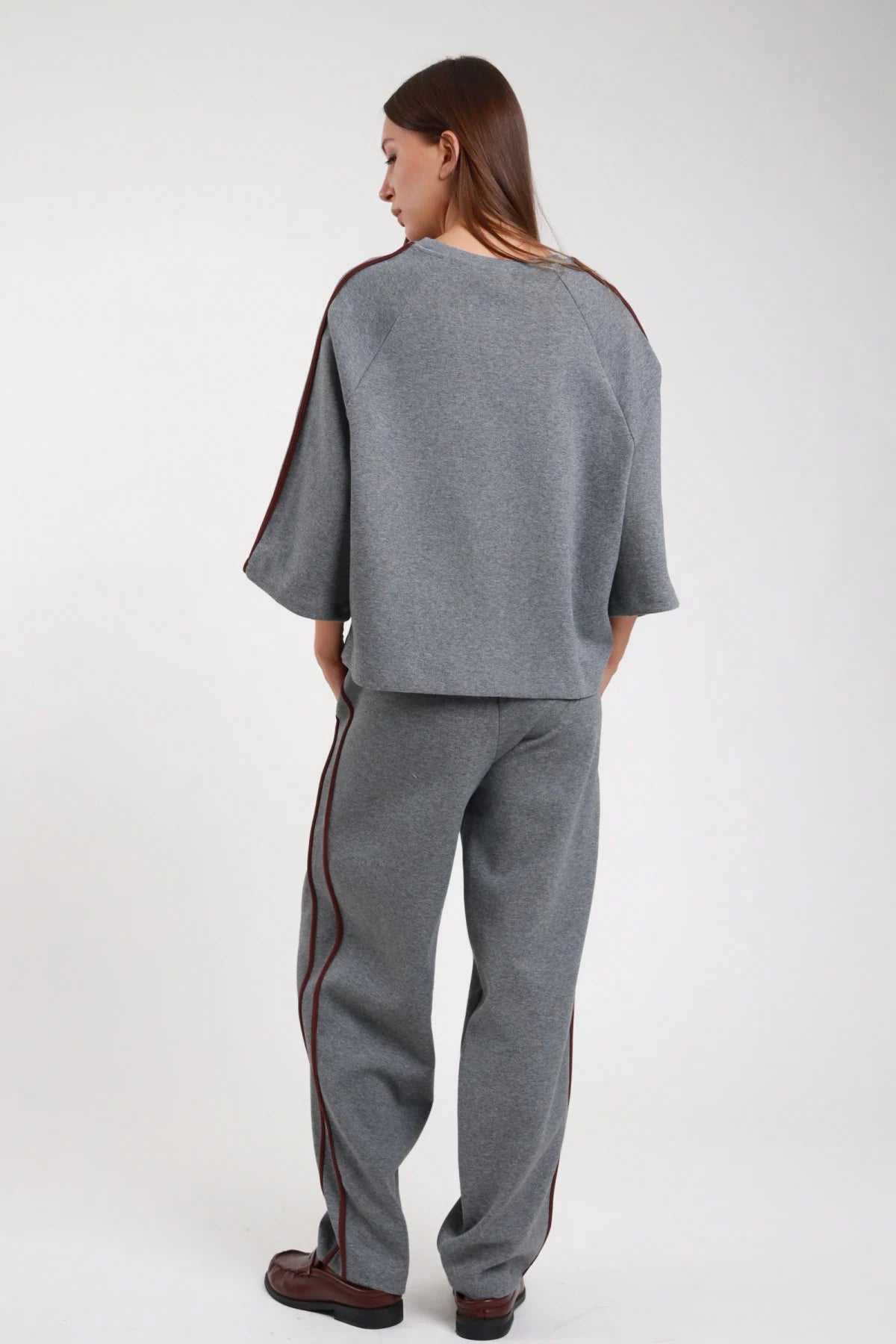 Pantalone barrel bande nero frontale intera coordinato felpa nera bande giallo lime vita elastica gamba barrel wide leg - modella frontale intera mani tasche sguardo frontale felpa nera bande lime stivaletti neri capelli castani raccolti