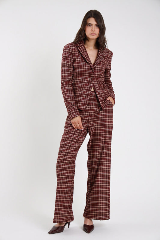 Pantalone Check tartan quadri bordeaux ruggine wide leg palazzo maxi vita elastico frontale intera con Blazer Check bordeaux - modella frontale intera mano tasca sguardo laterale capelli castani scuri sfondo bianco blazer check bordeaux kitten heel bordeaux vernice