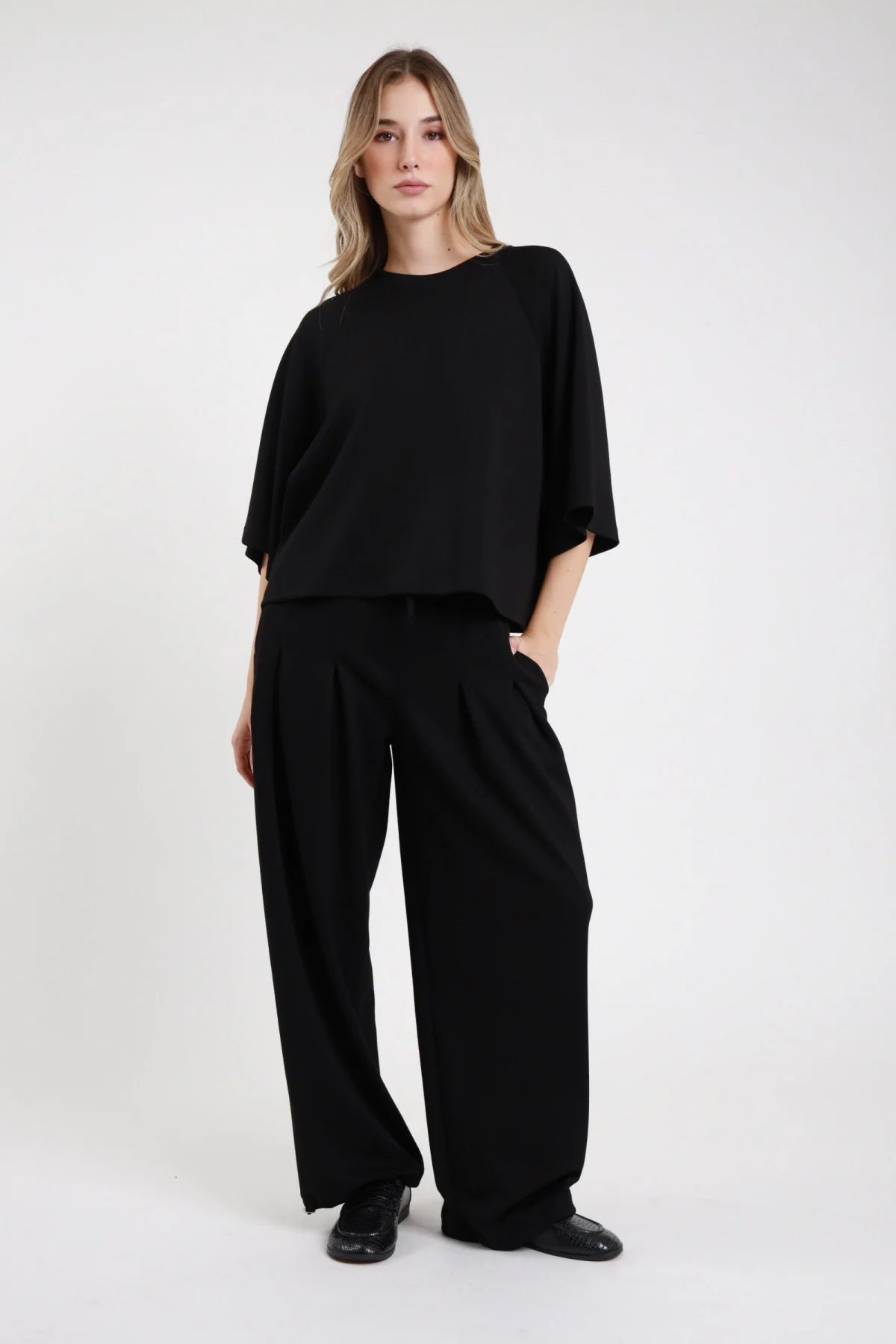 Pantalone felpa palazzo Susy Mix nero con pieghe frontali e tasche laterali, vista frontale indossata