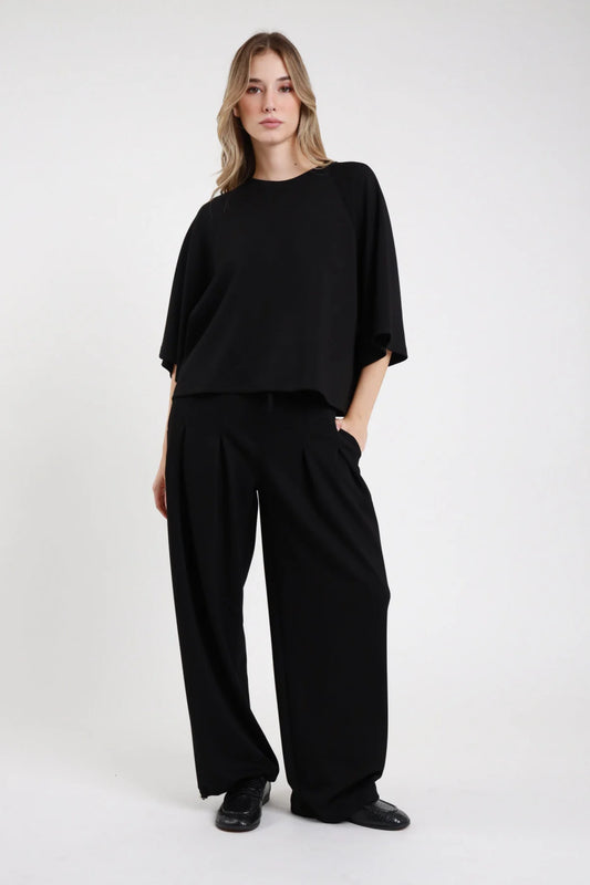 Pantalone felpa palazzo Susy Mix nero con pieghe frontali e tasche laterali, vista frontale indossata