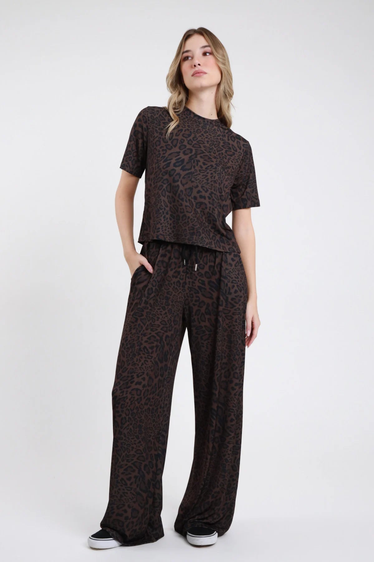 Pantalone animalier da donna a gamba ampia in stampa maculata scura, vista frontale indossato con top coordinato