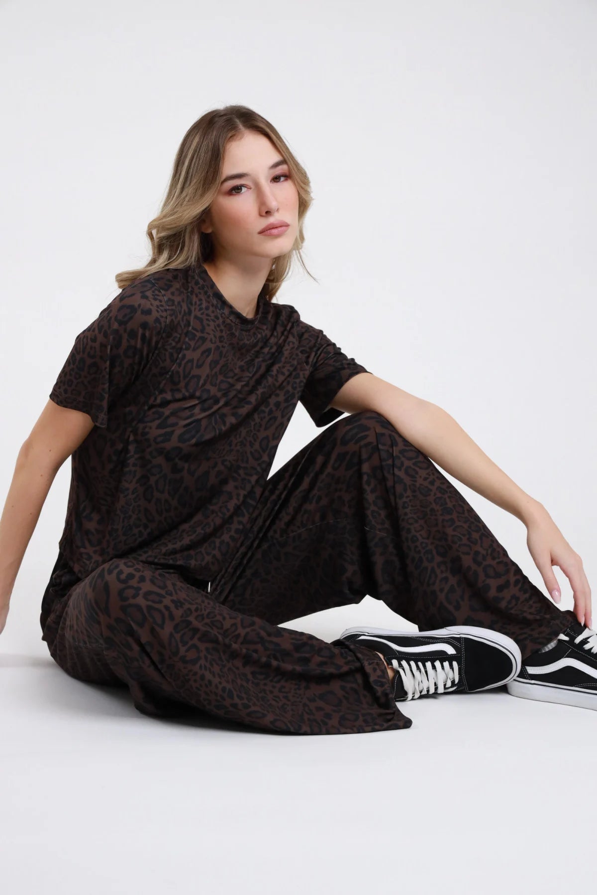Pantalone animalier scuro a gamba ampia indossato da modella seduta con top coordinato