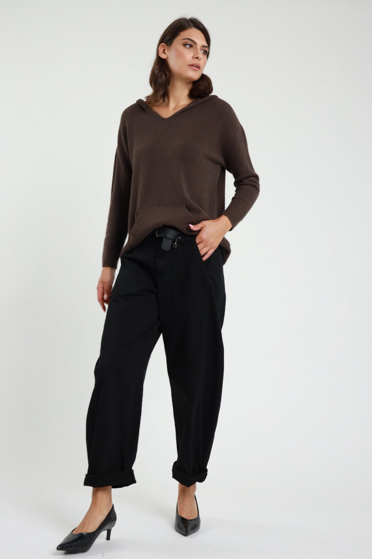 Pantalone Stellina ovetto balloon vita alta pinces risvolto affusolato cammello tabacco frontale intera - modella frontale intera sguardo frontale capelli castani scuri sfondo bianco giacca ecopelle nera décolleté neri kitten heel