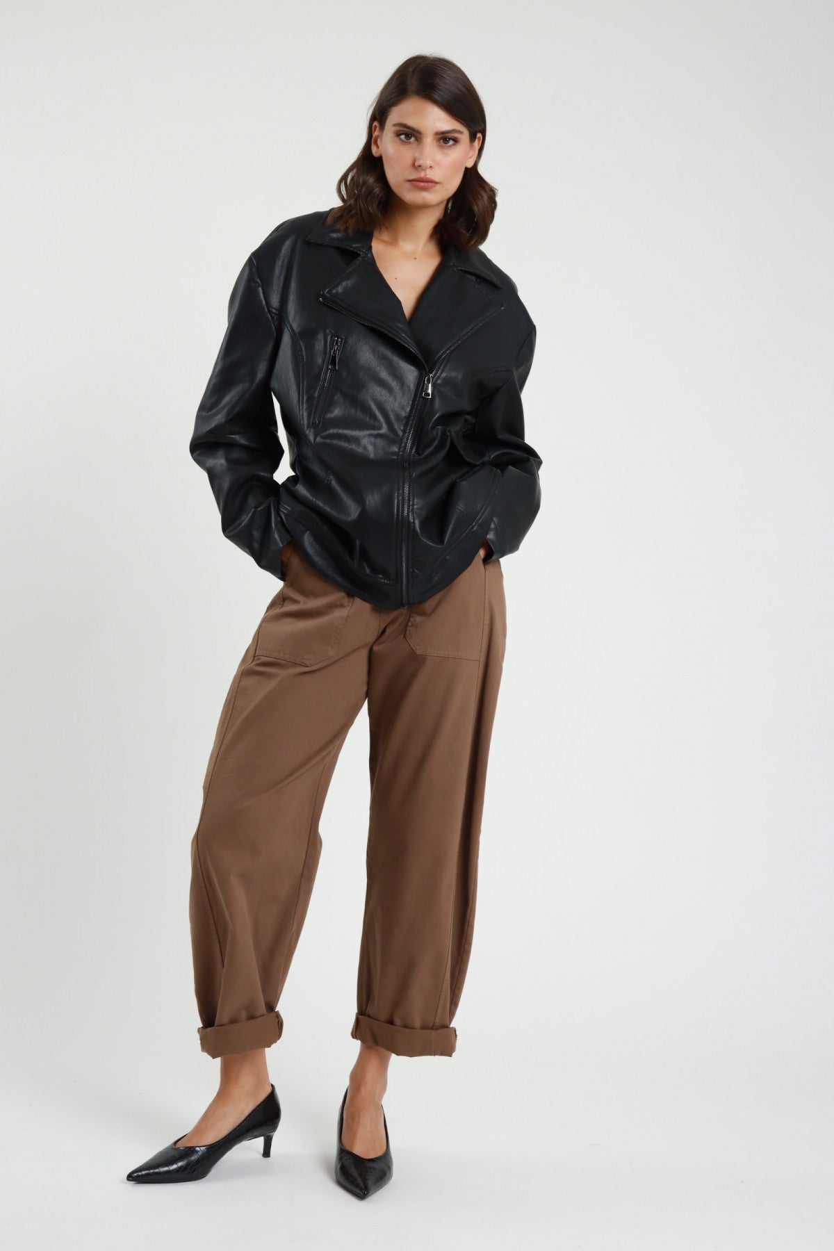 Pantalone Stellina ovetto balloon vita alta pinces risvolto affusolato blu navy indaco frontale intera - modella frontale intera sguardo laterale capelli castani scuri sfondo bianco maglia manica corta marrone cintura nera décolleté neri kitten heel