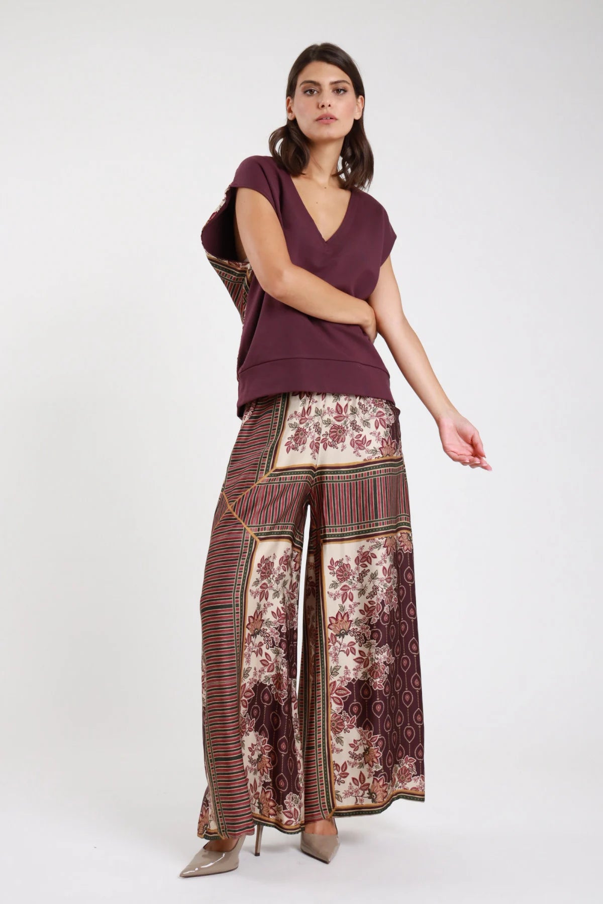 Pantalone palazzo fantasia patchwork bordeaux panna - modella vista frontale con top bordeaux e décolleté nude