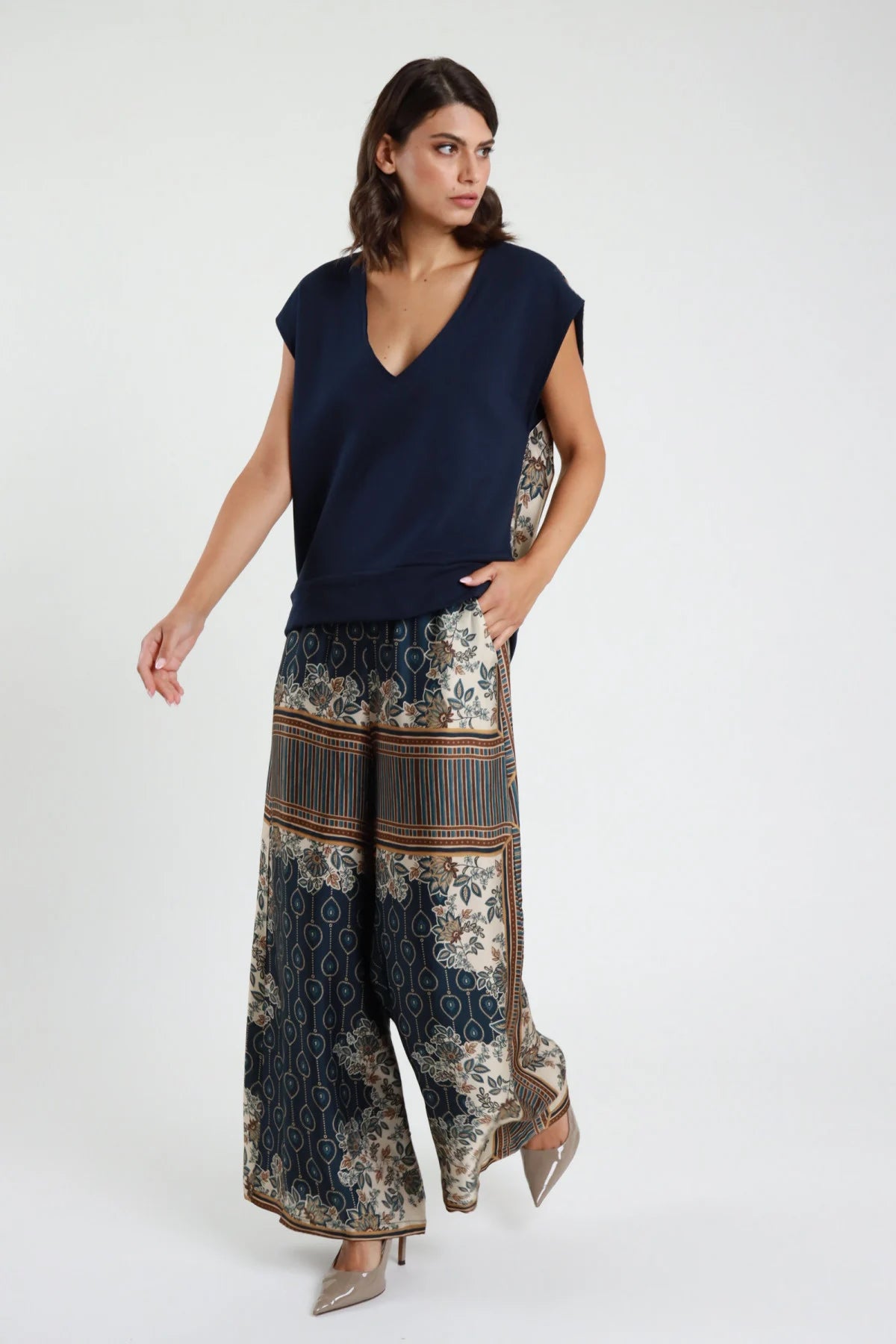 Pantalone palazzo fantasia patchwork blu navy panna - modella vista frontale con top navy e décolleté nude