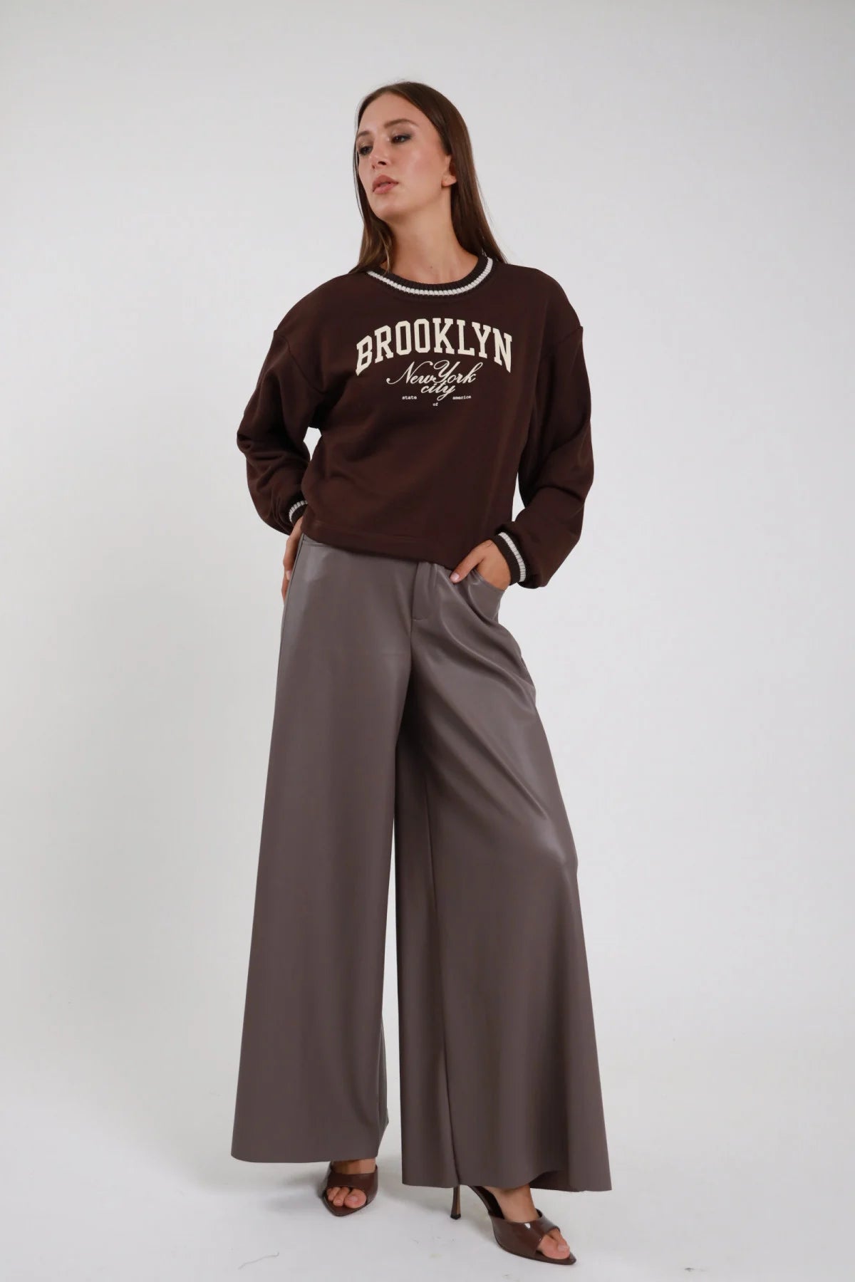 Pantalone palazzo grigio da donna a gamba ampia, indossato con felpa marrone, vista frontale