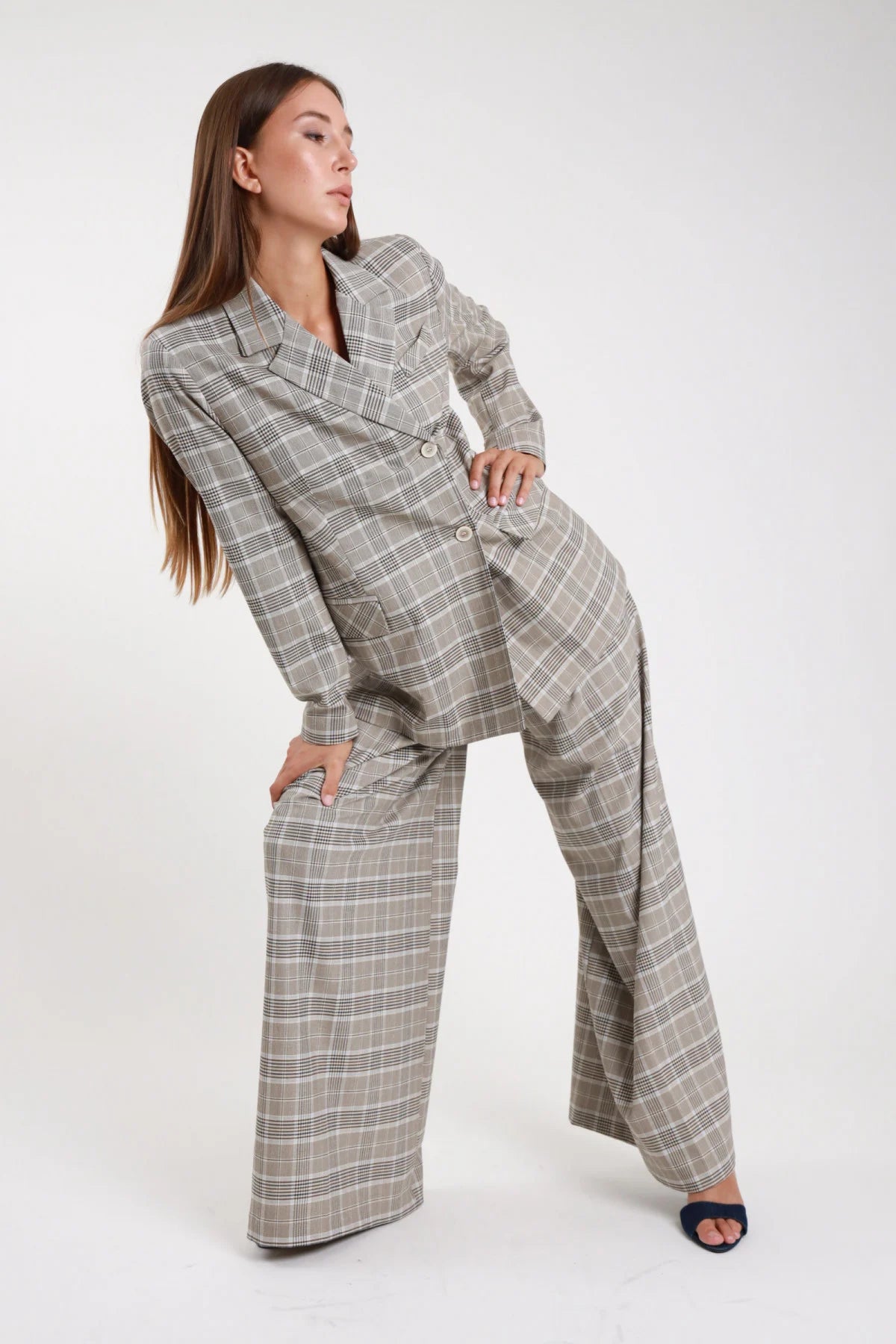 Pantalone palazzo check principe di galles grigio beige - modella posa laterale dinamica con blazer check coordinato e sandali blu