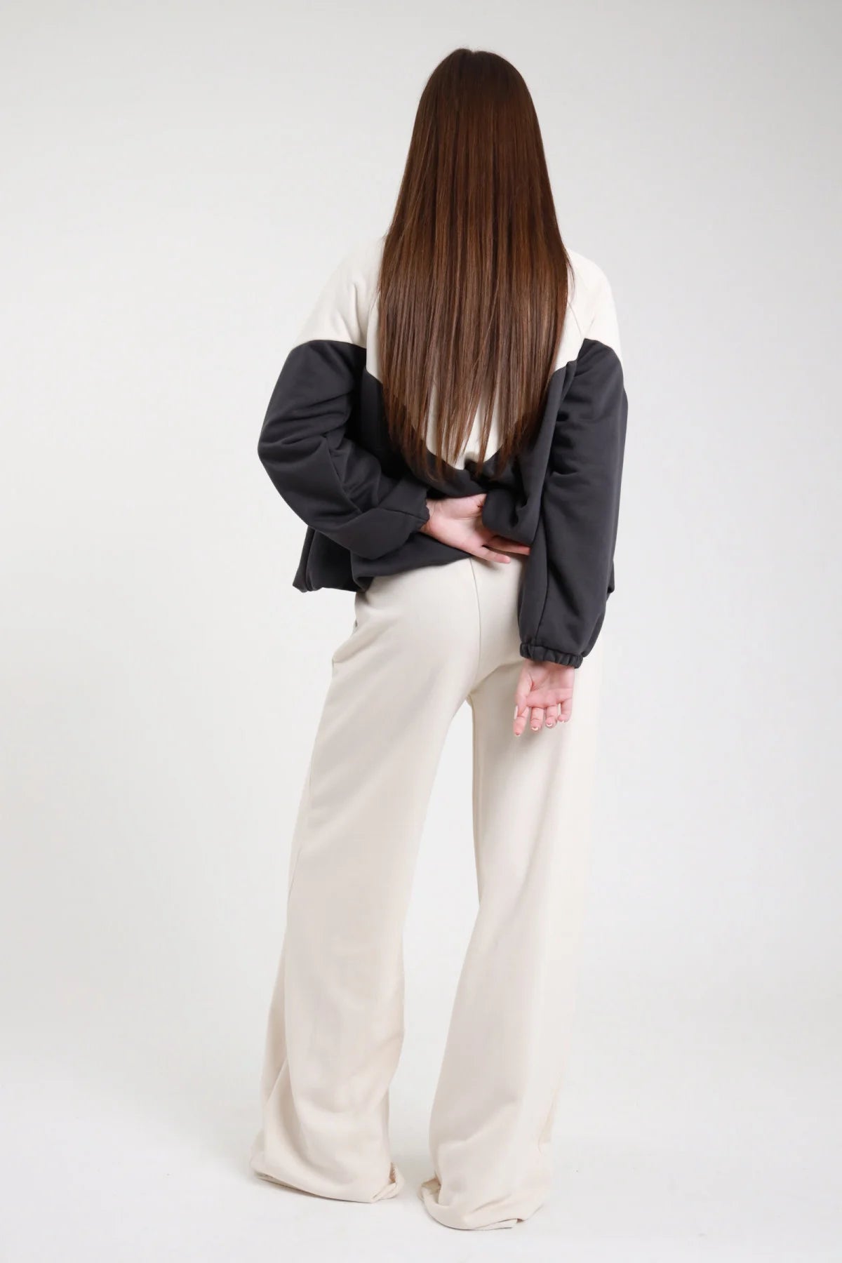 Pantalone felpa palazzo wide leg beige panna fascia elastica coulisse vita tasche gamba diritta full-length retro intera - modella retro intera capelli castani lisci lunghi sfondo bianco felpa bicolor bianco antracite