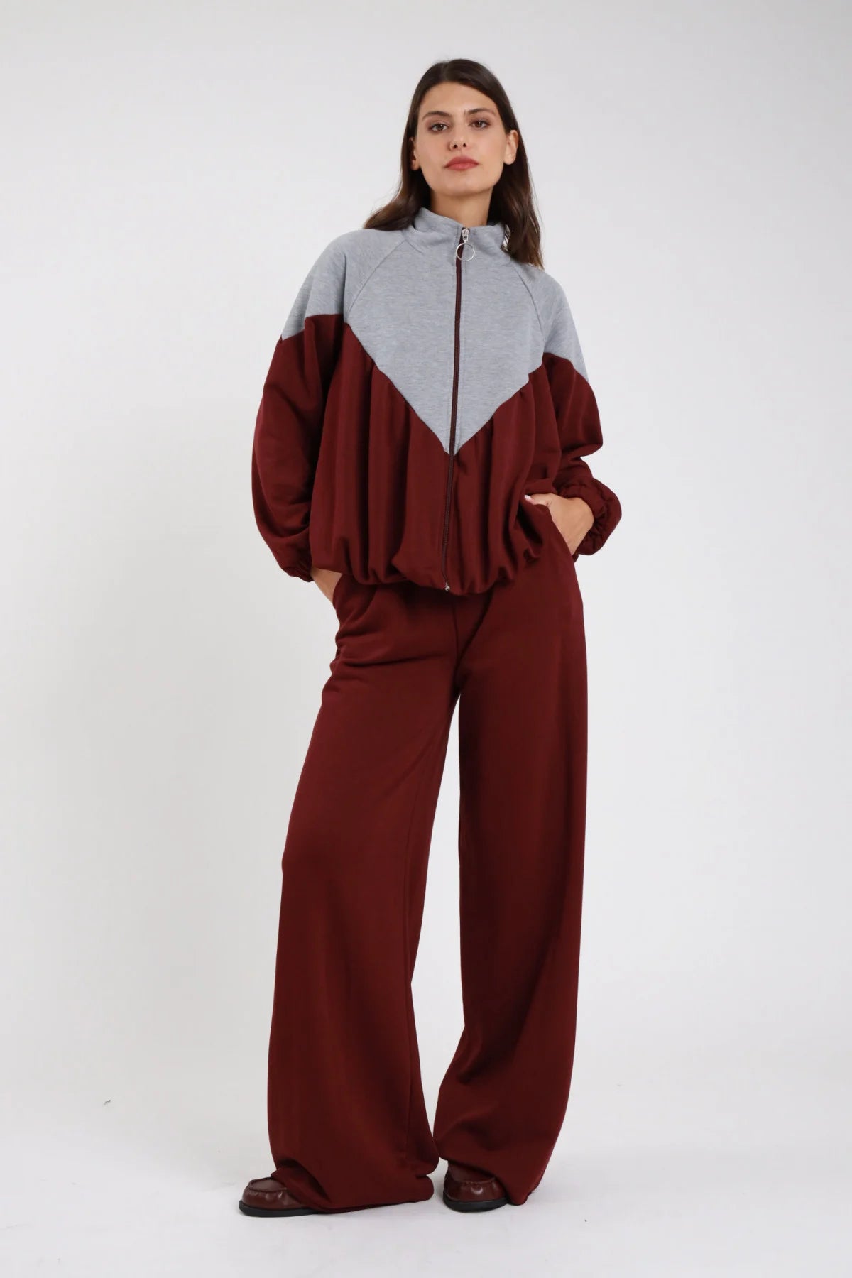 Pantalone felpa palazzo wide leg antracite grigio scuro fascia elastica coulisse vita tasche gamba diritta full-length frontale intera - modella frontale intera mani fianchi sguardo frontale capelli castani lisci sfondo bianco felpa bicolor bianco antracite sneakers argento