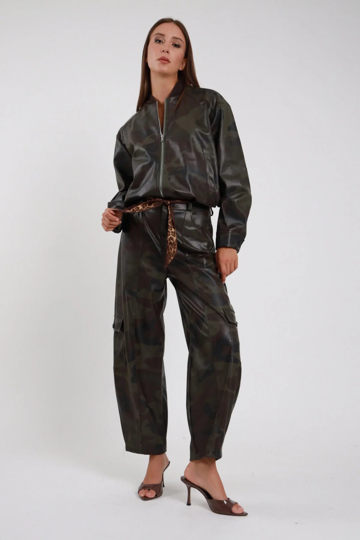 Pantalone Tasconi Mimetico cargo barrel ecopelle PU camouflage verde bronzo tasconi laterali vita media cintura leopardata polsino elastico frontale intera in piedi - modella frontale intera mano bomber sguardo frontale capelli castani lisci sfondo bianco bomber coordinato mimetico mules tacco marrone