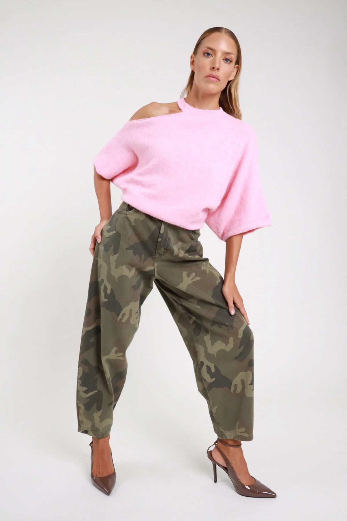 Jeans pantalone barrel slouchy mimetico tre quarti frontale dinamico gamba balloon cavallo basso - modella tre quarti frontale mano in tasca sguardo frontale pullover cut-out rosa slingback grigio capelli biondi