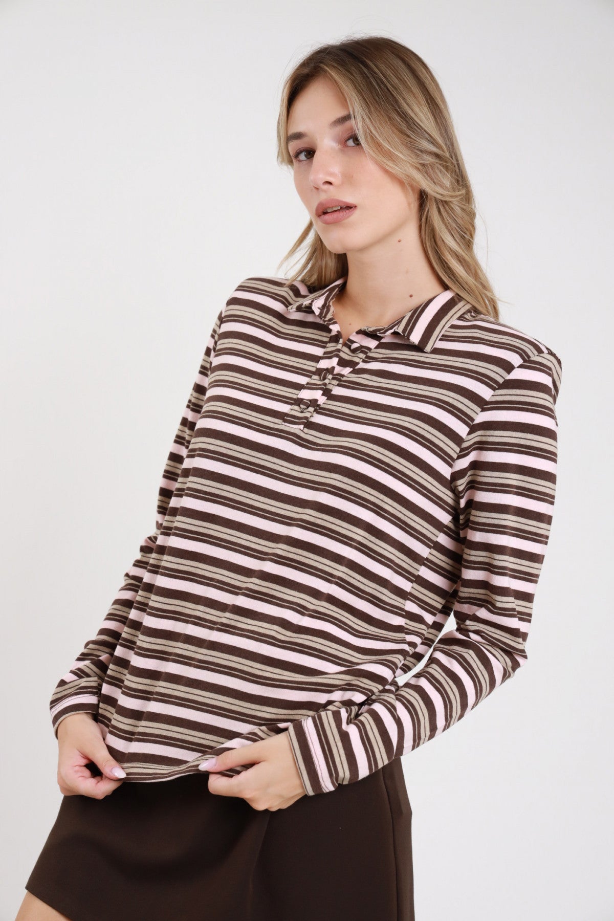 Polo righe rosa cipria cioccolato caramello frontale busto mani grembo colletto polo morbido placchetta 3 bottoni righe multicolor - modella frontale busto mani grembo sguardo laterale gonna cioccolato mini capelli biondi onde