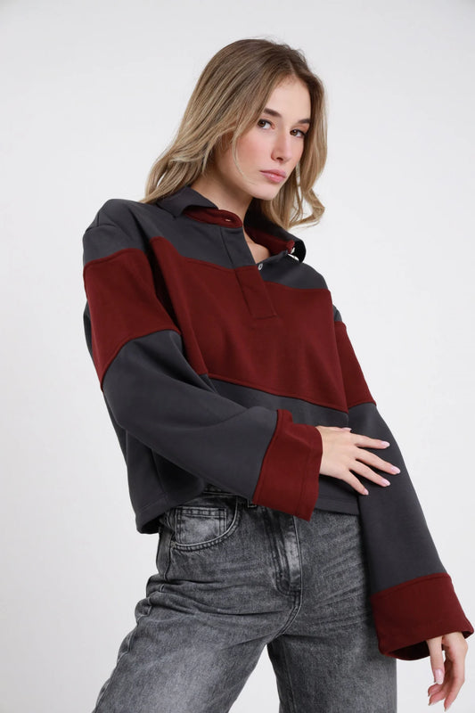 Polo Felpa Righe grigio antracite bordeaux barolo 65% cotone righe maxi orizzontali color block fasce larghissime colletto polo zip bottone manica lunga ampia oversize boxy corta frontale 3/4 laterale braccio corpo - modella 3/4 laterale braccio corpo sguardo laterale capelli biondi mossi sfondo bianco jeans grigio stone washed abbinati