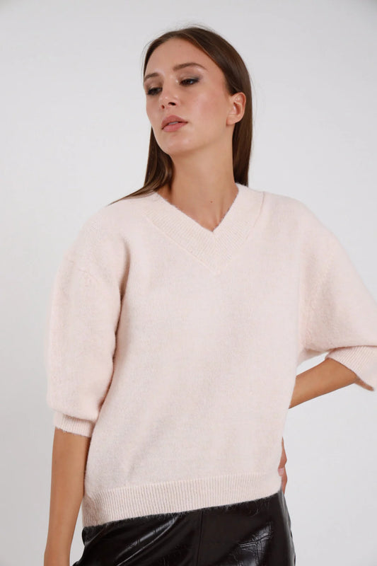 Pullover Scollo V rosa cipria blush maglia ultra morbida effetto cashmere scollo V ampio manica 3/4 balloon risvolto orlo coste oversize boxy busto frontale 3/4 sguardo basso - modella busto frontale 3/4 sguardo basso capelli castani sfondo bianco gonna ecopelle nera orecchino piccolo dorato