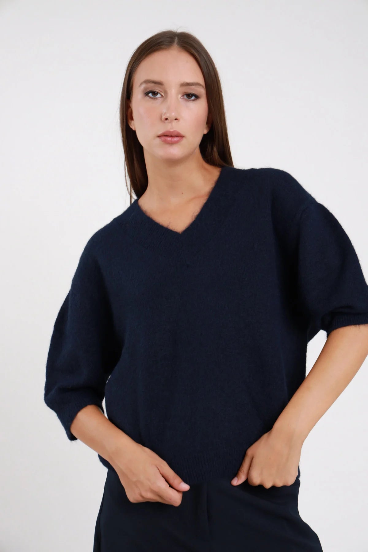 Pullover Scollo V blu navy maglia ultra morbida scollo V ampio manica 3/4 balloon risvolto orlo coste oversize boxy busto frontale 3/4 mani tasche sguardo frontale - modella busto frontale 3/4 mani tasche sguardo frontale capelli castani sfondo bianco pantalone coordinato blu navy