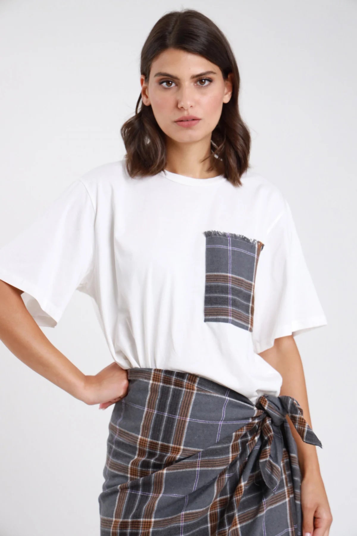 T-shirt oversize bianca con taschina check grigia sfrangiata - vista frontale modella