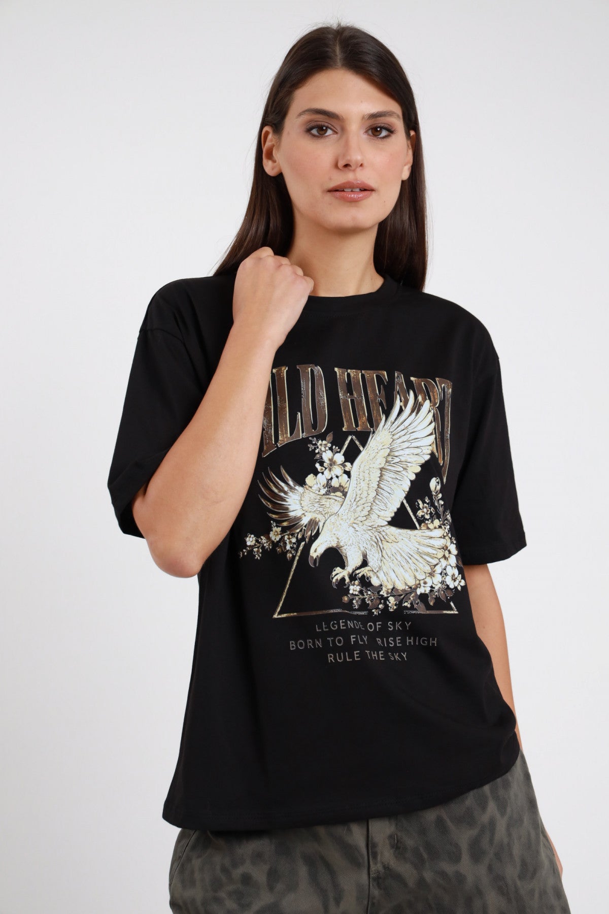 T-shirt Wild Heart Susy Mix Pre-Fall nera 100% cotone stampa frontale Wild Heart aquila dorata bianca fiori Legend of Sky Born to Fly Rise High Rule the Sky girocollo manica corta oversize relaxed busto frontale pugno mento sguardo frontale - modella busto frontale pugno mento sguardo frontale capelli scuri lisci sfondo bianco gonna pantaloni mimetico scuro abbinati