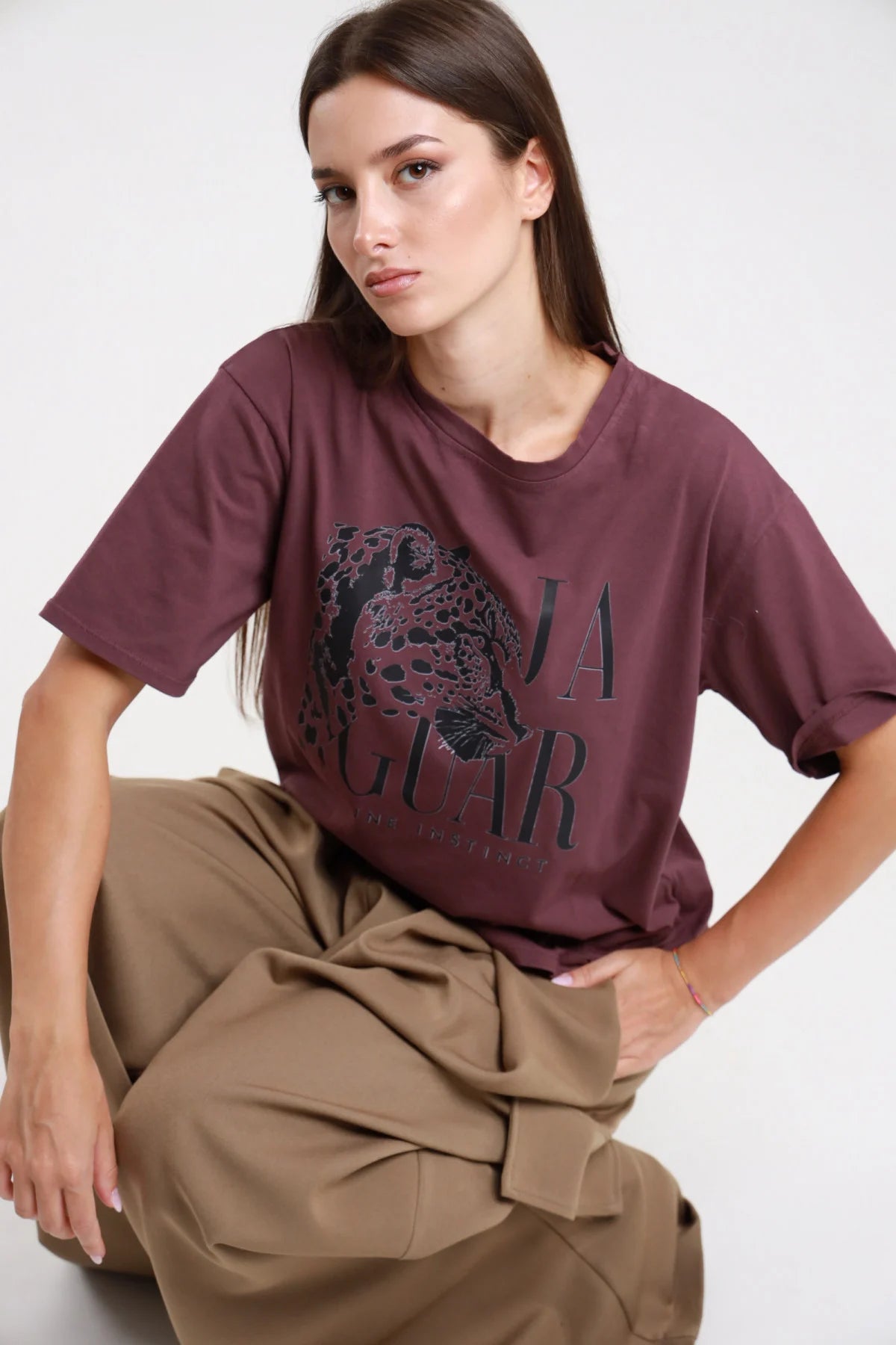 T-shirt Jaguar bordeaux prugna donna boxy oversize con stampa giaguaro - vista seduta con pantaloni cargo kaki