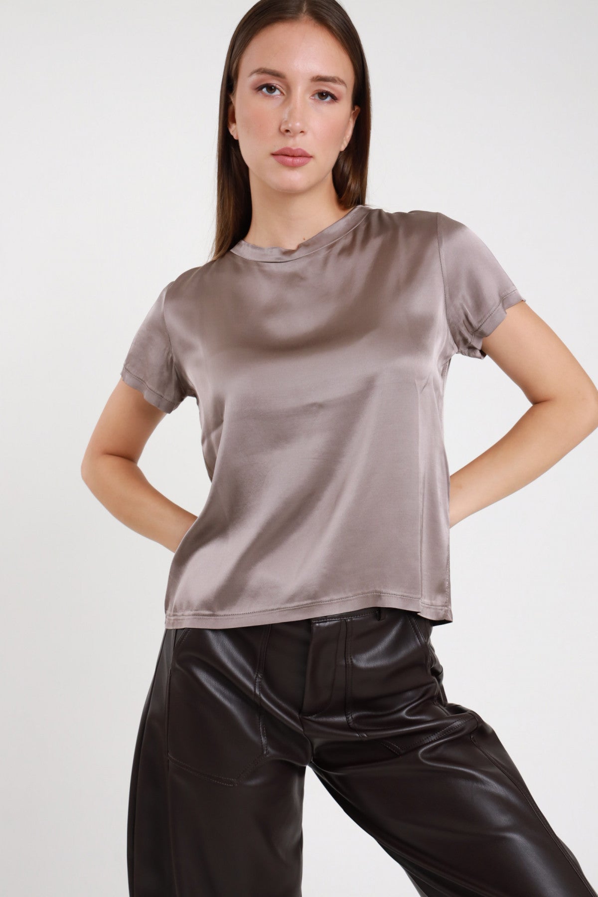 T-shirt stretch satinata tortora con girocollo abbinata a pantaloni in pelle neri